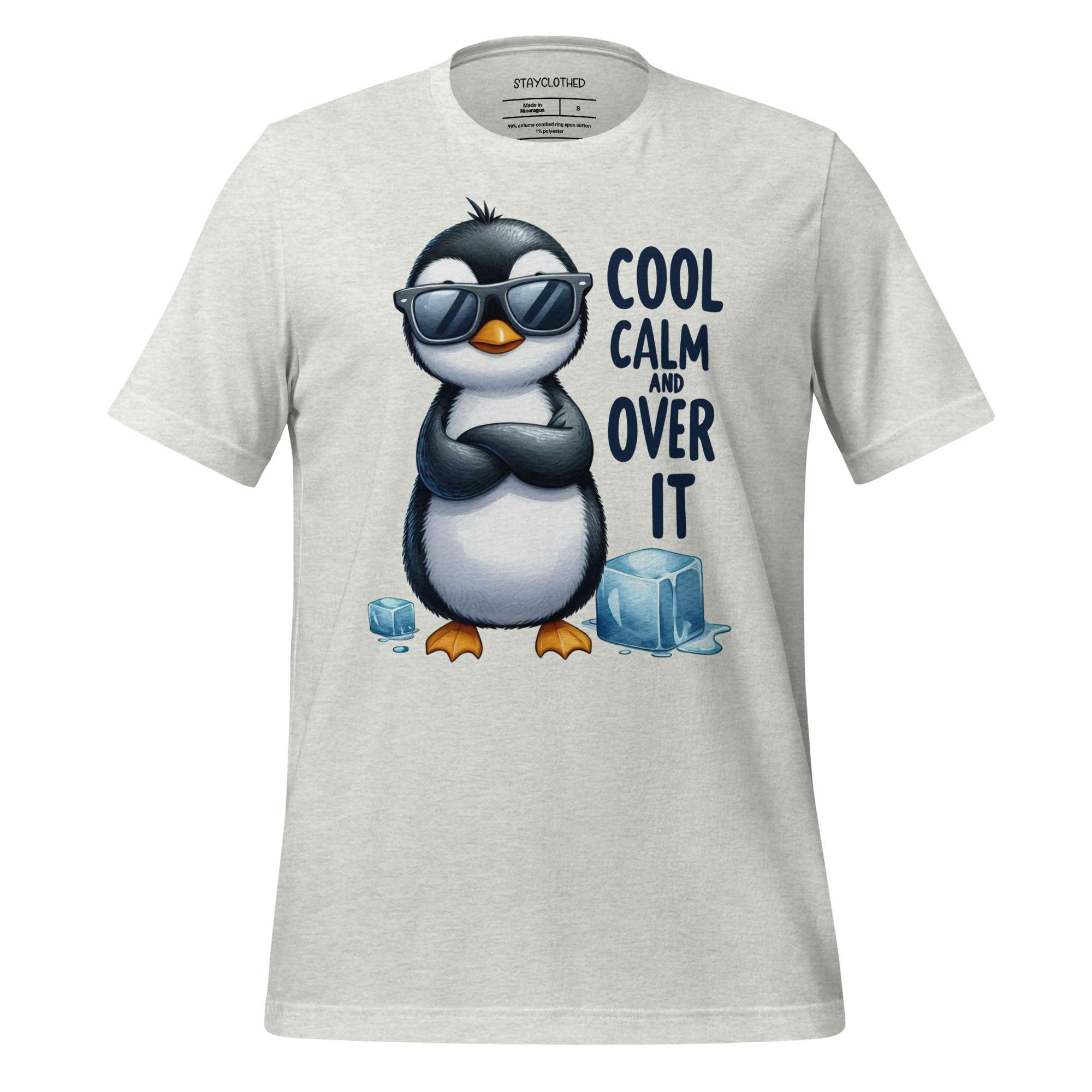 White t-shirt with a penguin graphic and text on a wooden surface, featuring the brand 'StayClothed'.