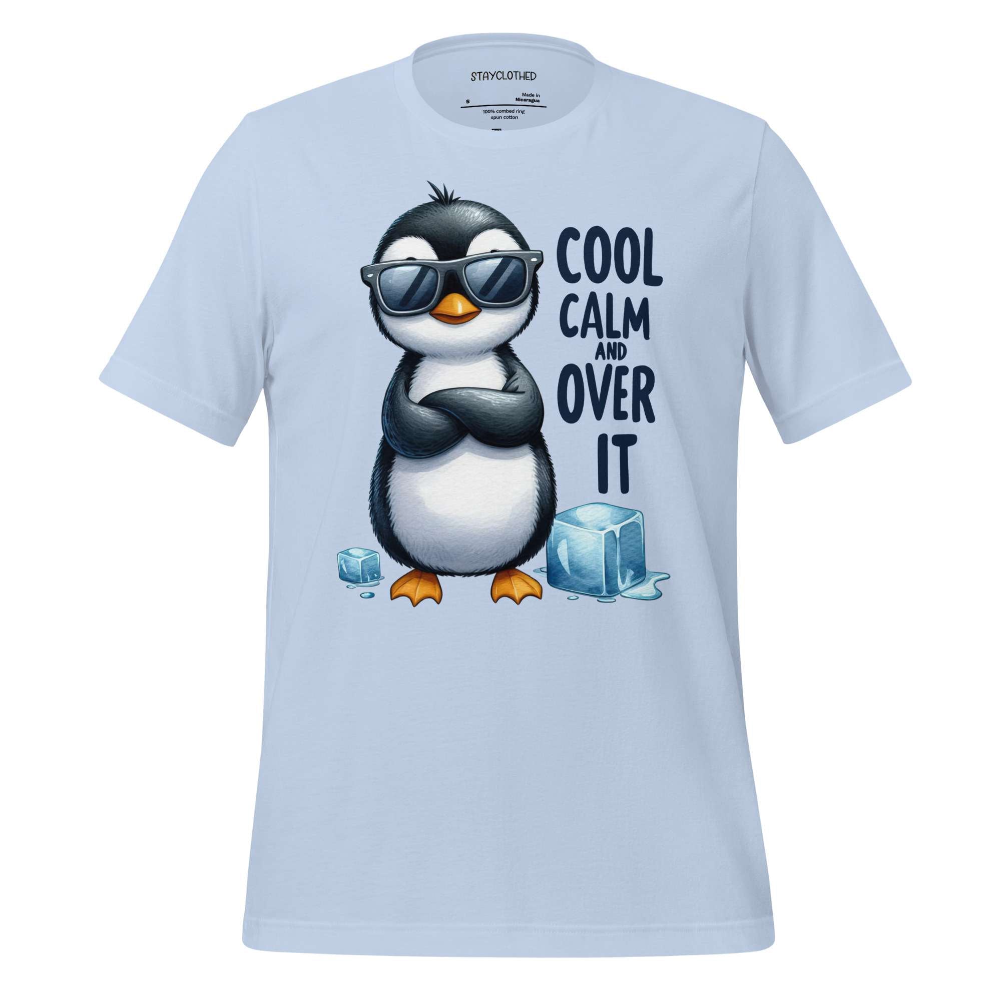 White t-shirt with a penguin graphic and text on a wooden surface, featuring the brand 'StayClothed'.