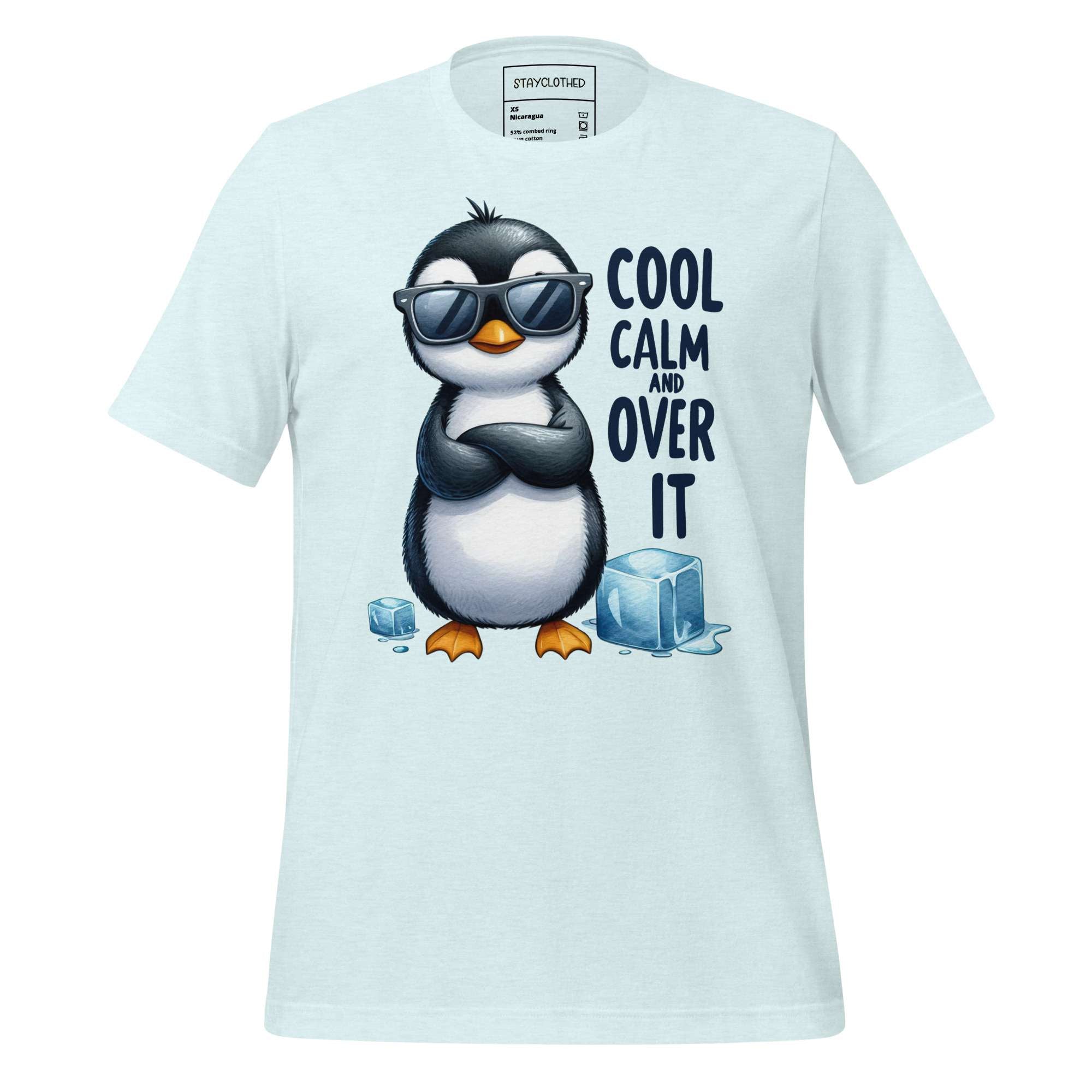 White t-shirt with a penguin graphic and text on a wooden surface, featuring the brand 'StayClothed'.