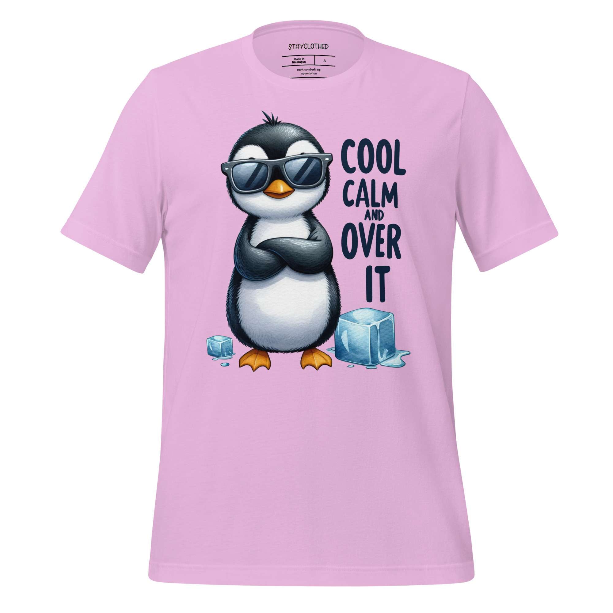 Pink t-shirt with a penguin graphic and text on a wooden surface, featuring the brand 'StayClothed'.