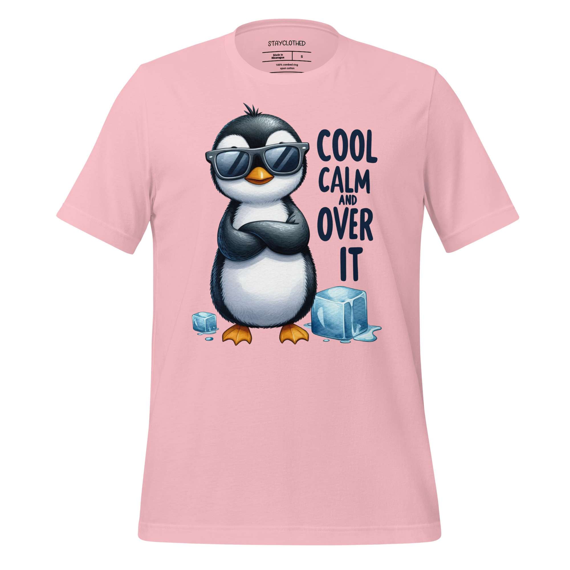 Pink t-shirt with a penguin graphic and text on a wooden surface, featuring the brand 'StayClothed'.