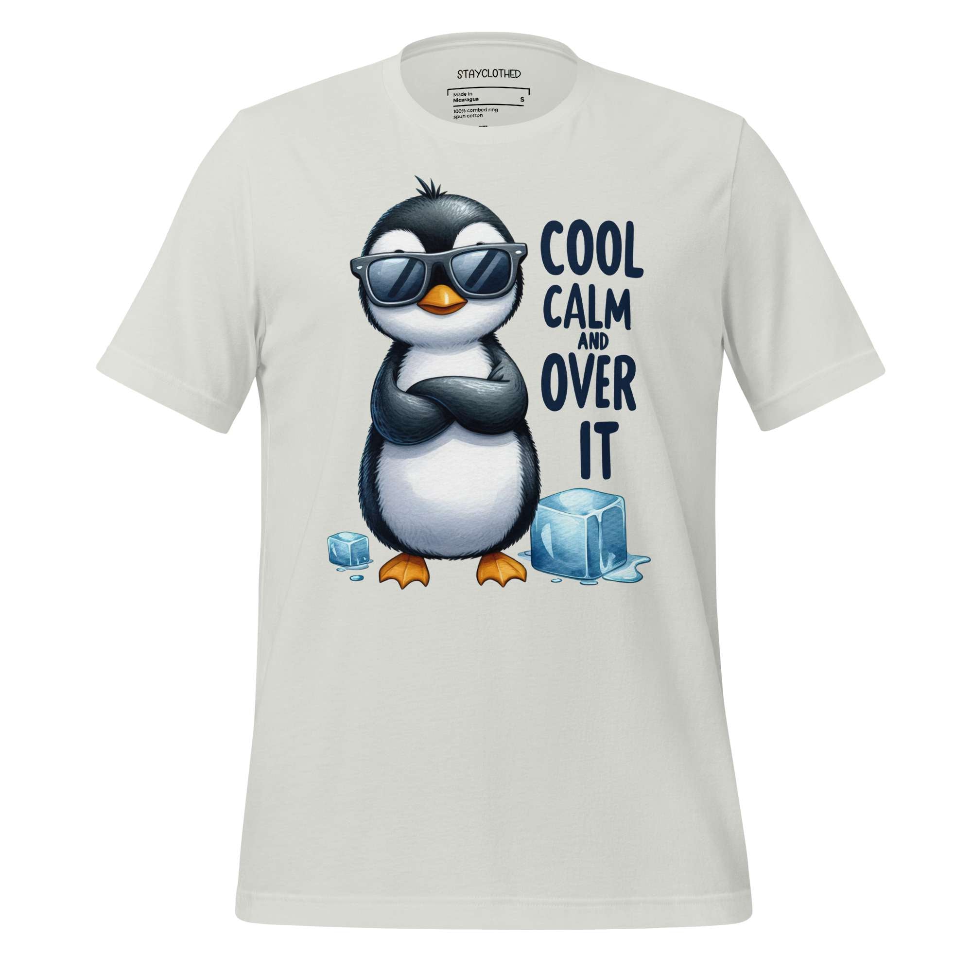 White t-shirt with a penguin graphic and text 'Cool Calm and Over It' on a wooden surface, featuring the brand 'StayClothed'.