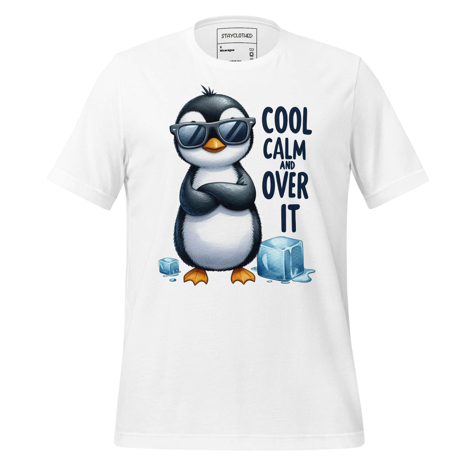 White t-shirt with a penguin graphic and text 'Cool Calm and Over It' on a wooden surface, featuring the brand 'StayClothed'.