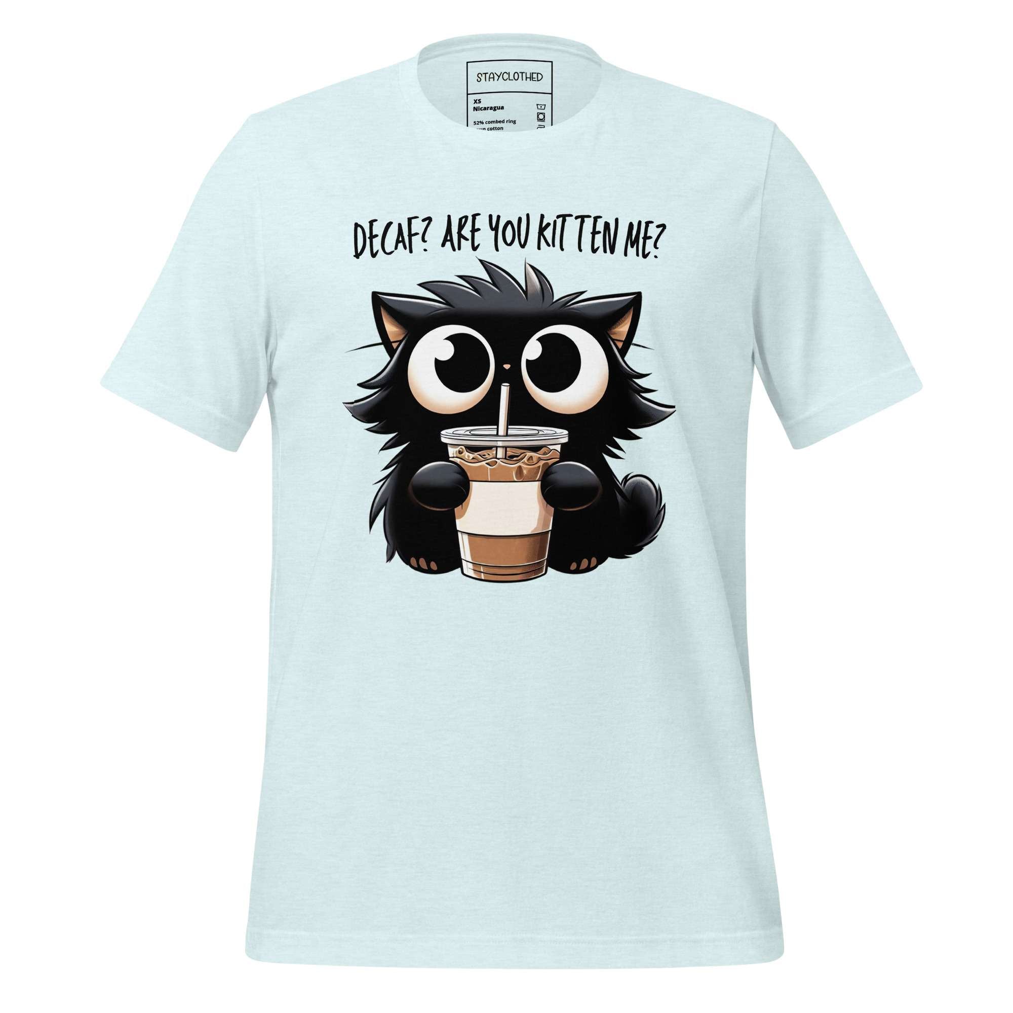 White t-shirt with a cartoon cat holding a coffee cup on a wooden surface, featuring the brand 'StayClothed'.