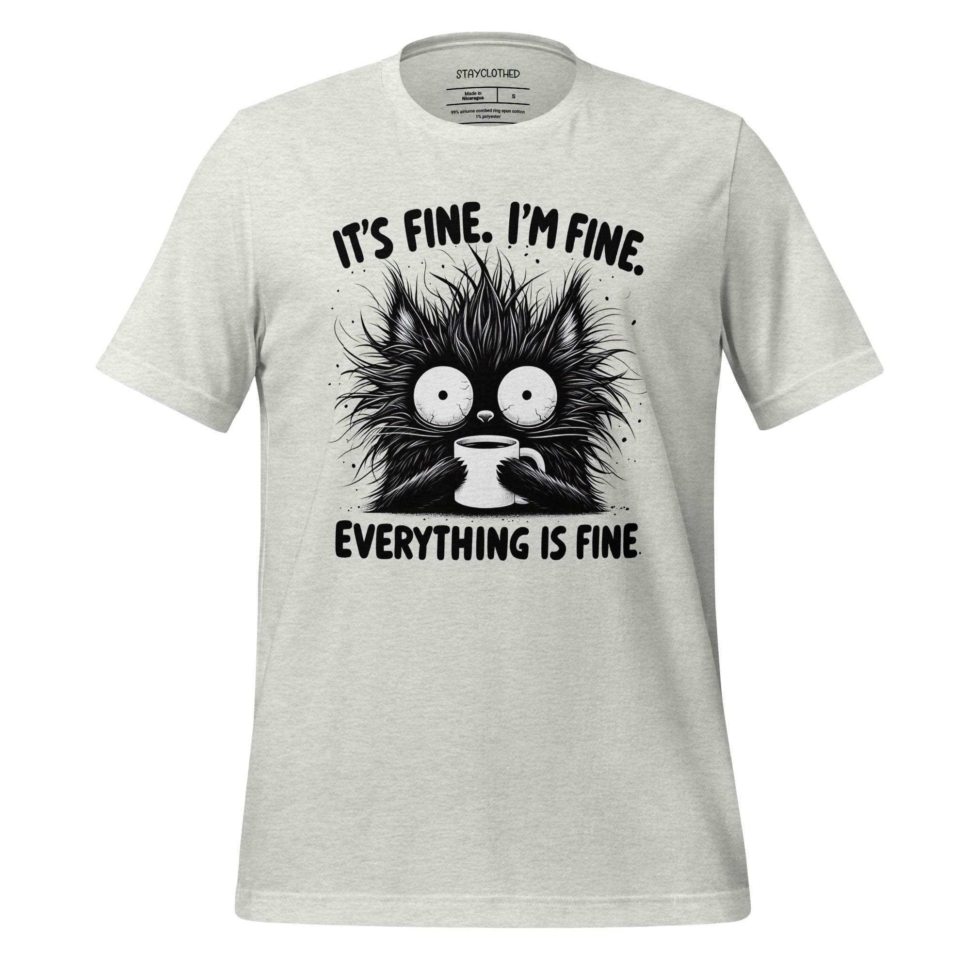 White t-shirt with a black cat graphic and text on a wooden surface, featuring the brand 'StayClothed'.