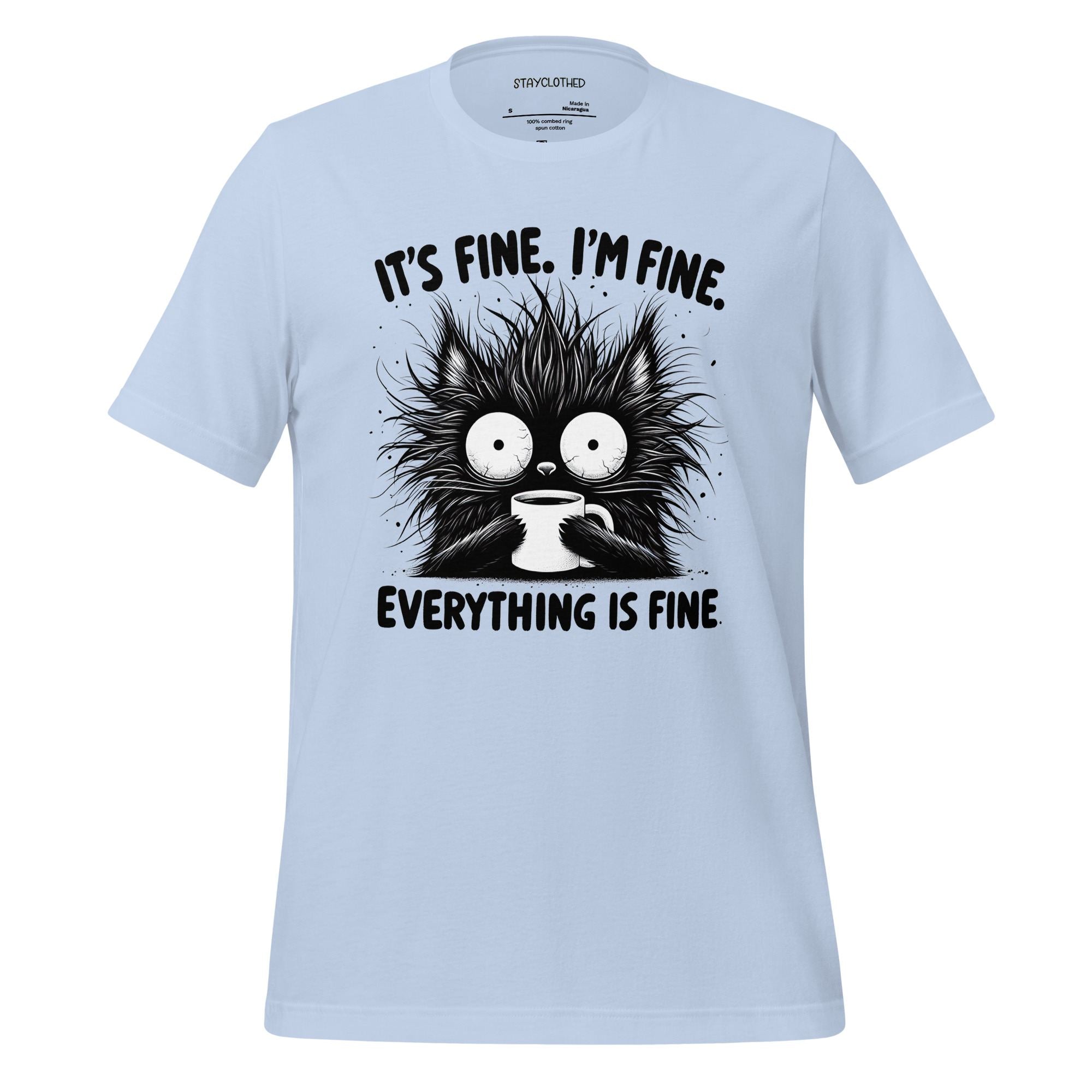 White t-shirt with a black cat graphic and text on a wooden surface, featuring the brand 'StayClothed'.