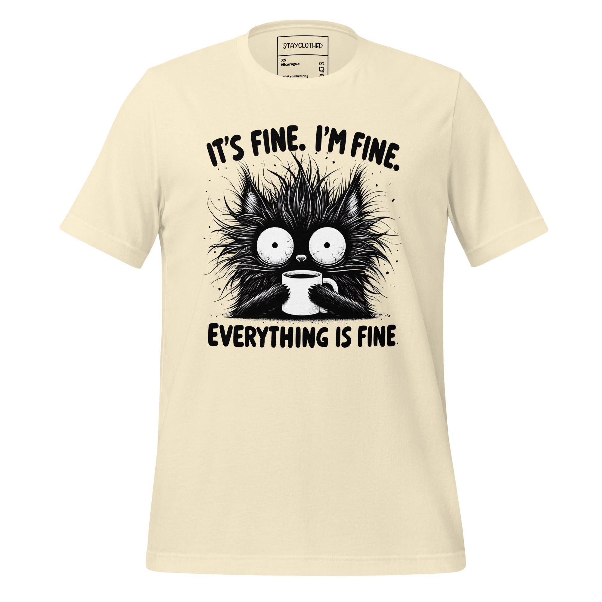Beige t-shirt with a graphic of a cat holding a coffee cup and text on a wooden surface, featuring the brand 'StayClothed'.
