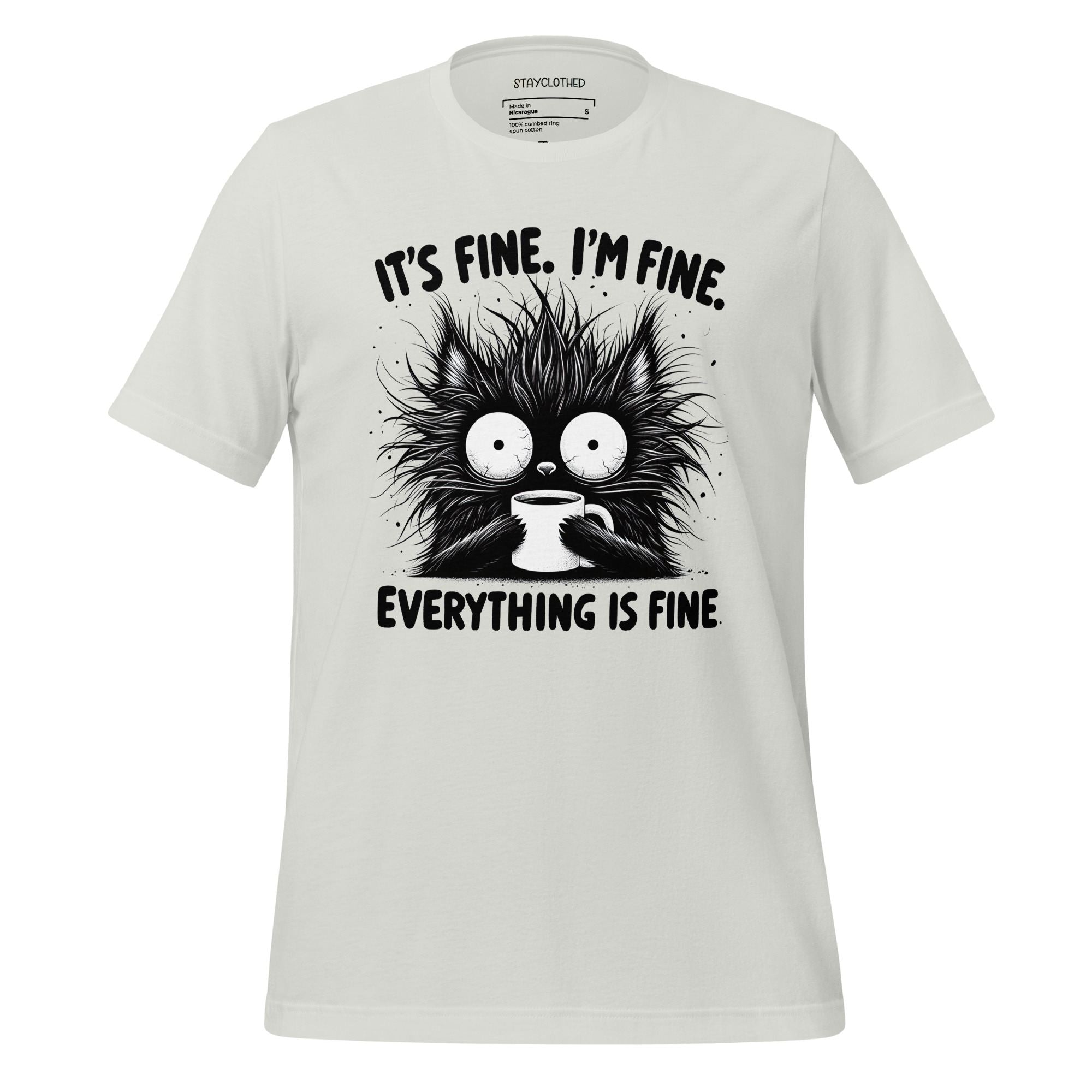 White t-shirt with a black cat graphic and text on a wooden surface, featuring the brand 'StayClothed'.