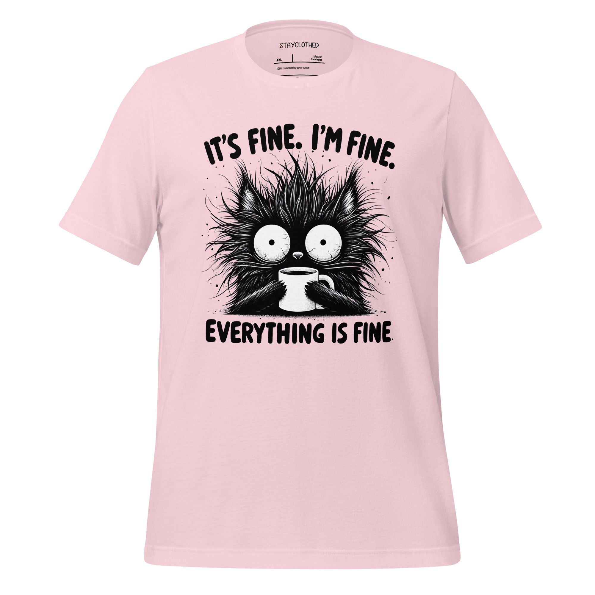 Pink t-shirt with a black cat graphic and text on a wooden surface, featuring the brand 'StayClothed'.