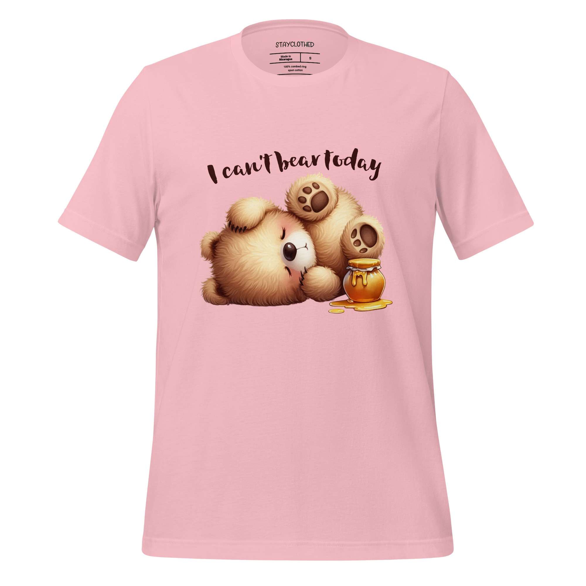 Pink t-shirt with cartoon bear and honey design on a wooden surface, featuring 'StayClothed' brand.