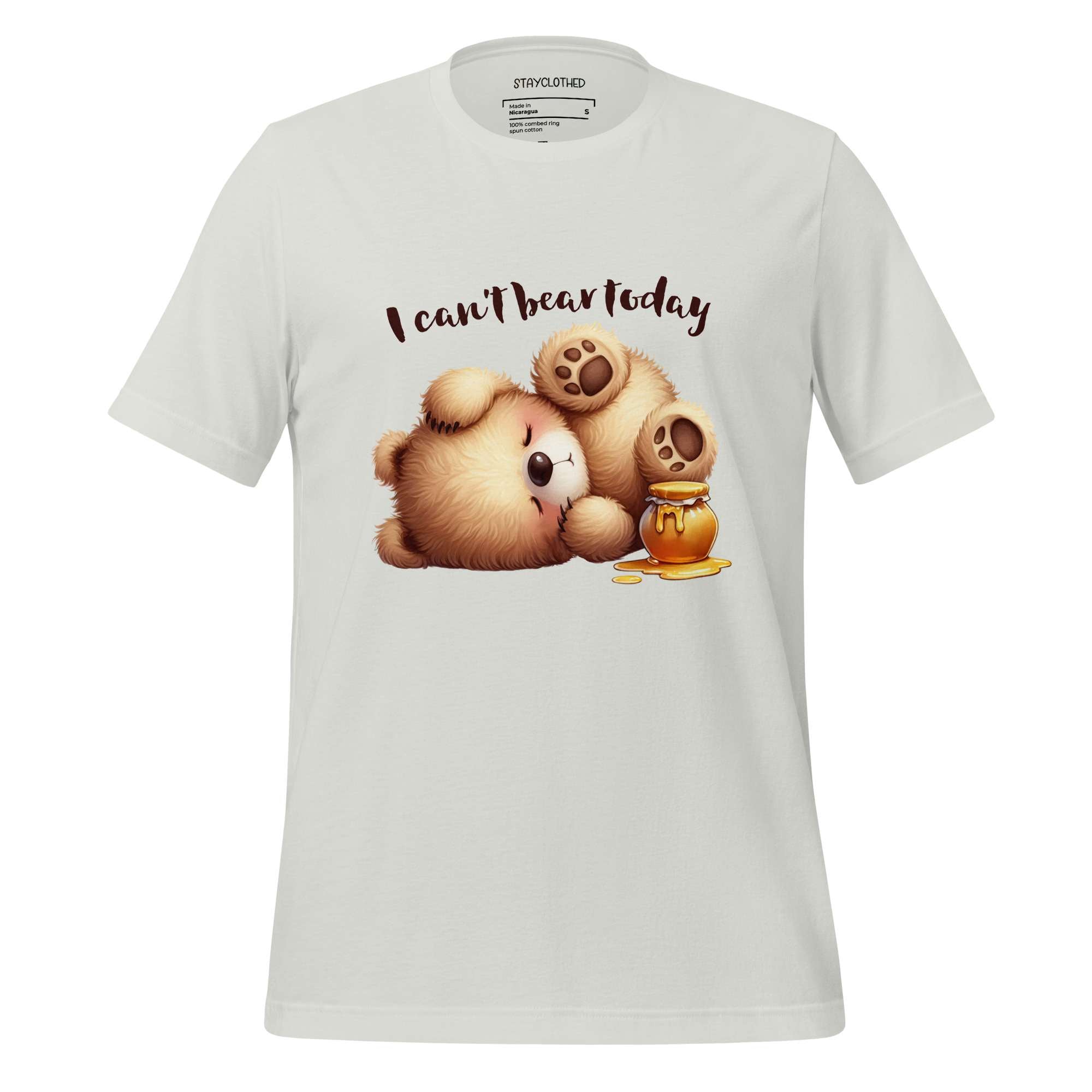 White t-shirt with cartoon bear and honey design on a wooden surface, featuring 'StayClothed' brand.