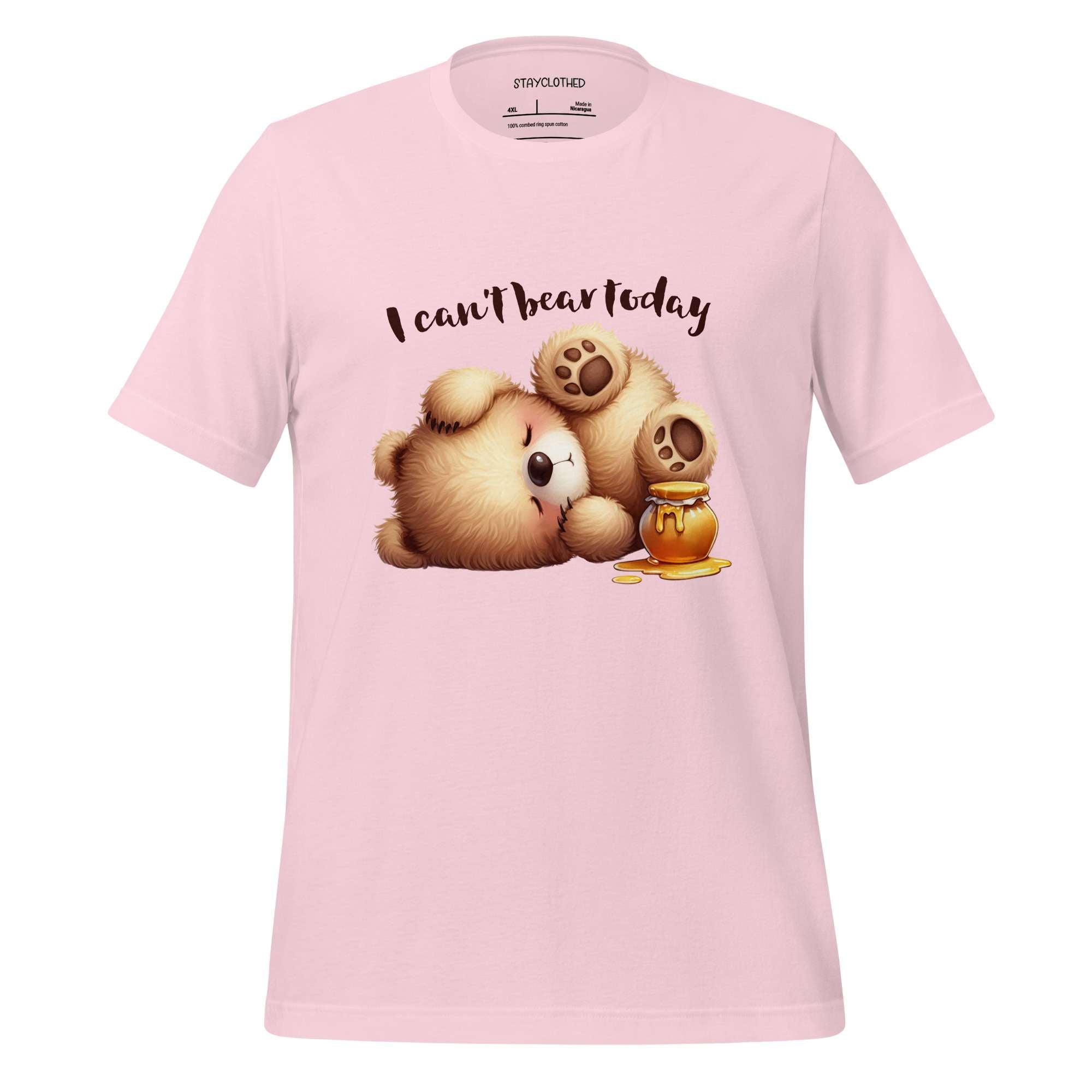 Pink t-shirt with a teddy bear and honeycomb graphic on a wooden surface, featuring the brand 'StayClothed'.
