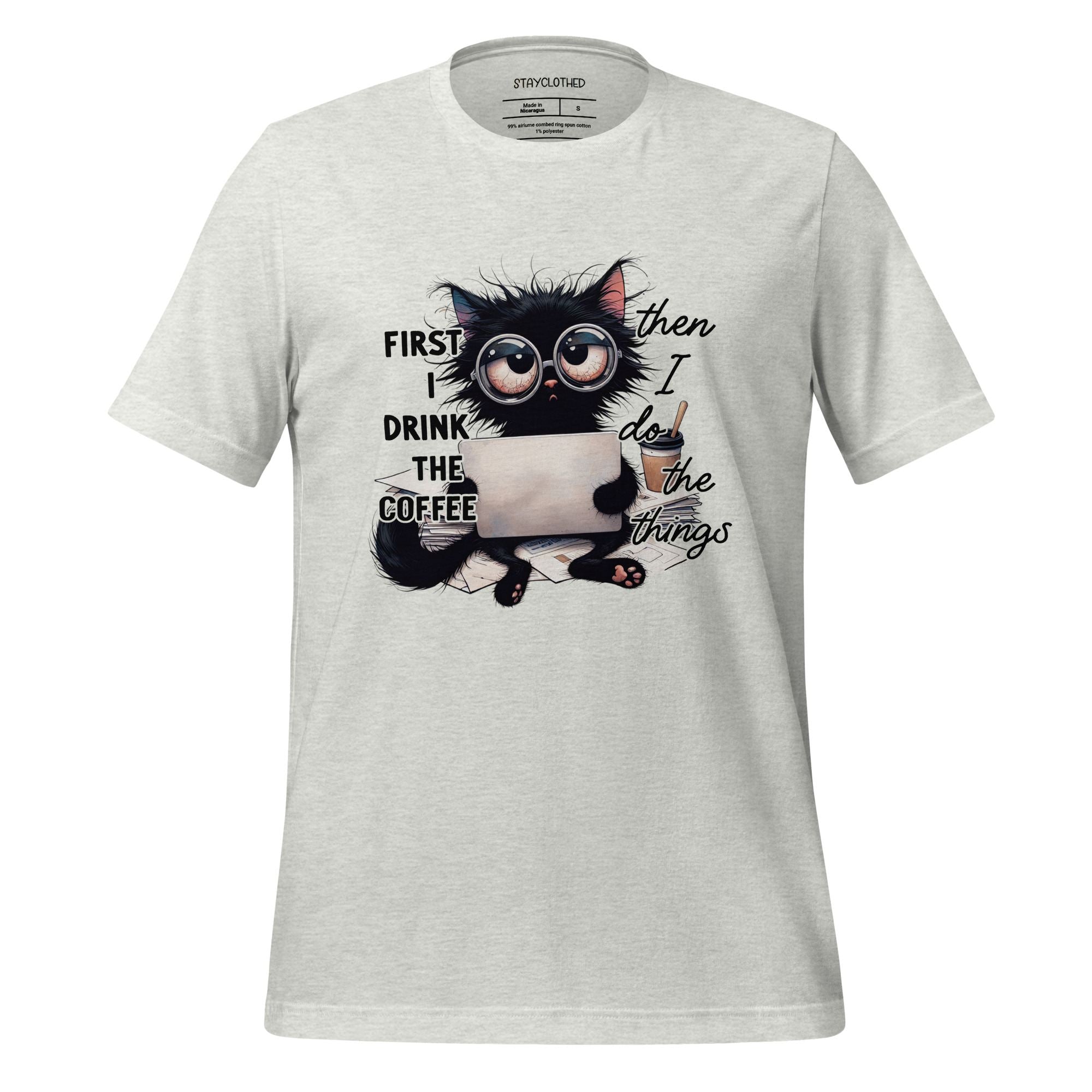 White t-shirt with a cat graphic and text on a wooden surface, featuring the brand 'StayClothed'.