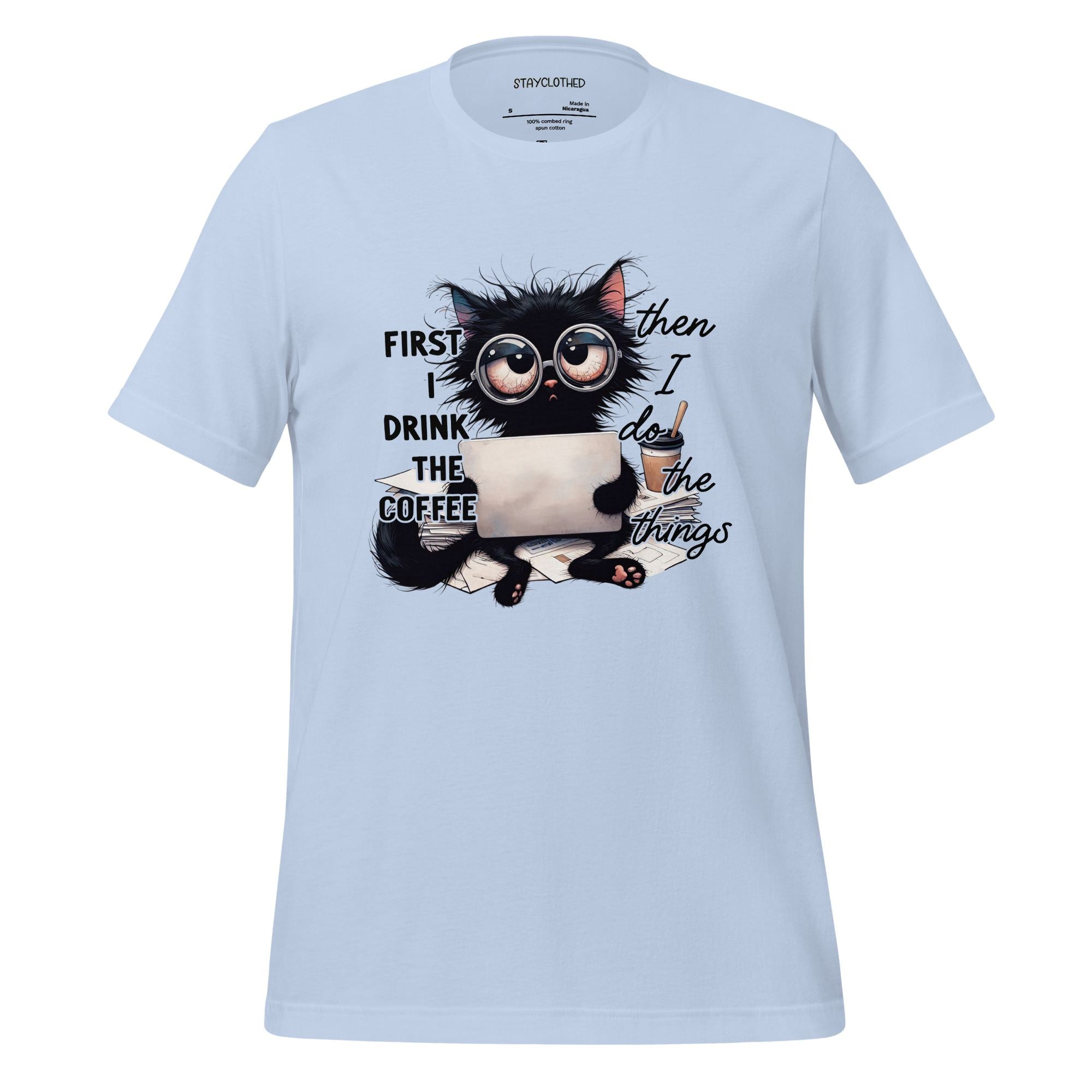 White t-shirt with a cat graphic and text on a wooden surface, featuring the brand 'StayClothed'.