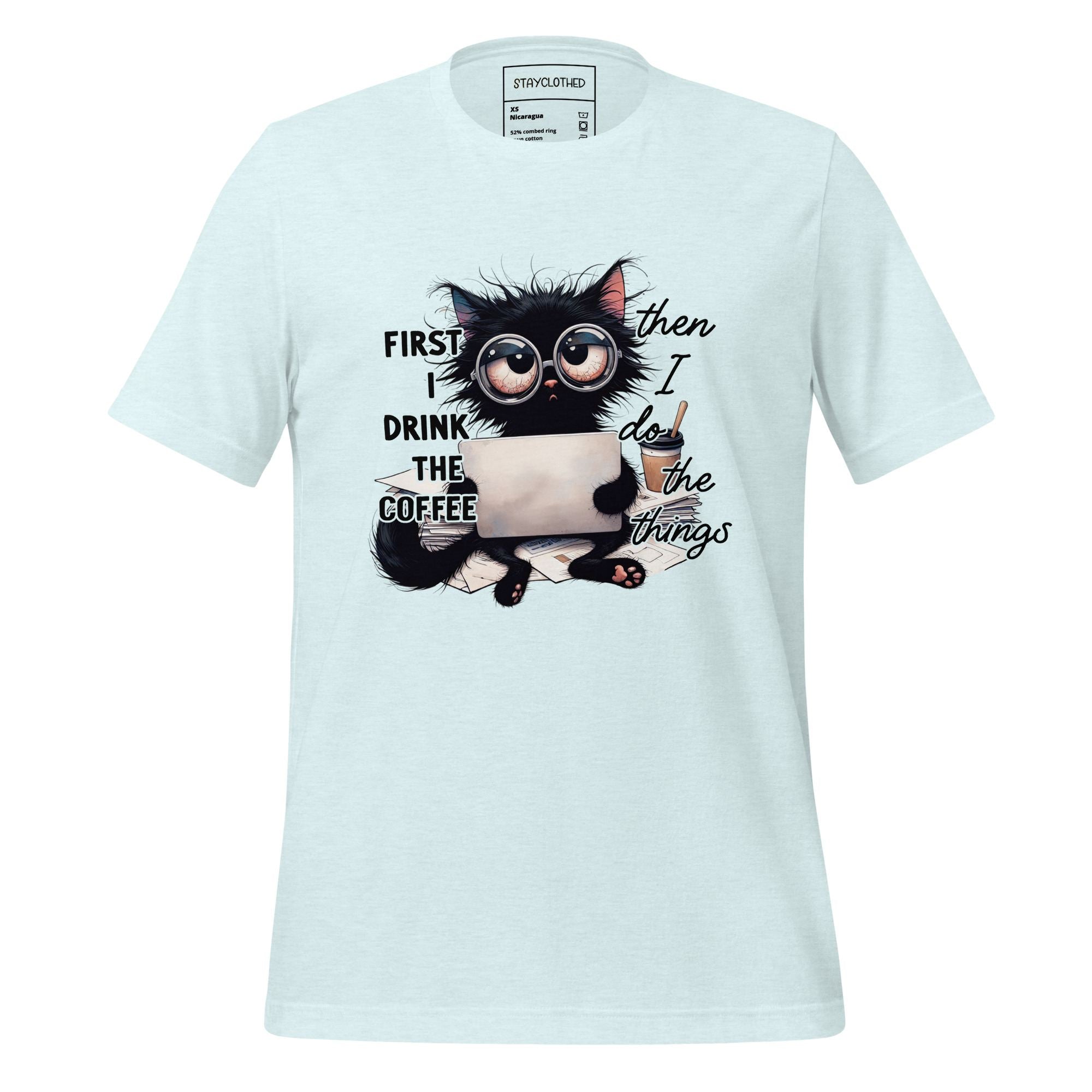 White t-shirt with a cat graphic and text on a wooden surface, featuring the brand 'StayClothed'.