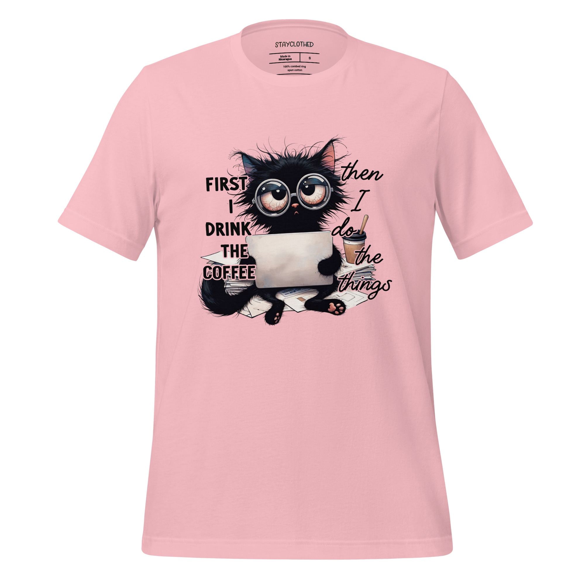 Pink t-shirt with a cat graphic and text on a wooden surface, featuring the brand 'StayClothed'.