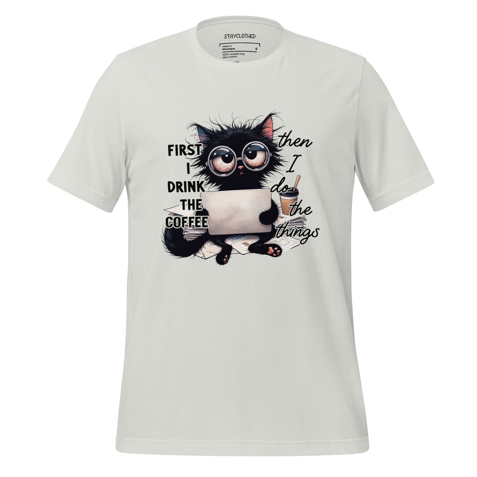 White t-shirt with a cat graphic and text on a wooden surface, featuring the brand 'StayClothed'.