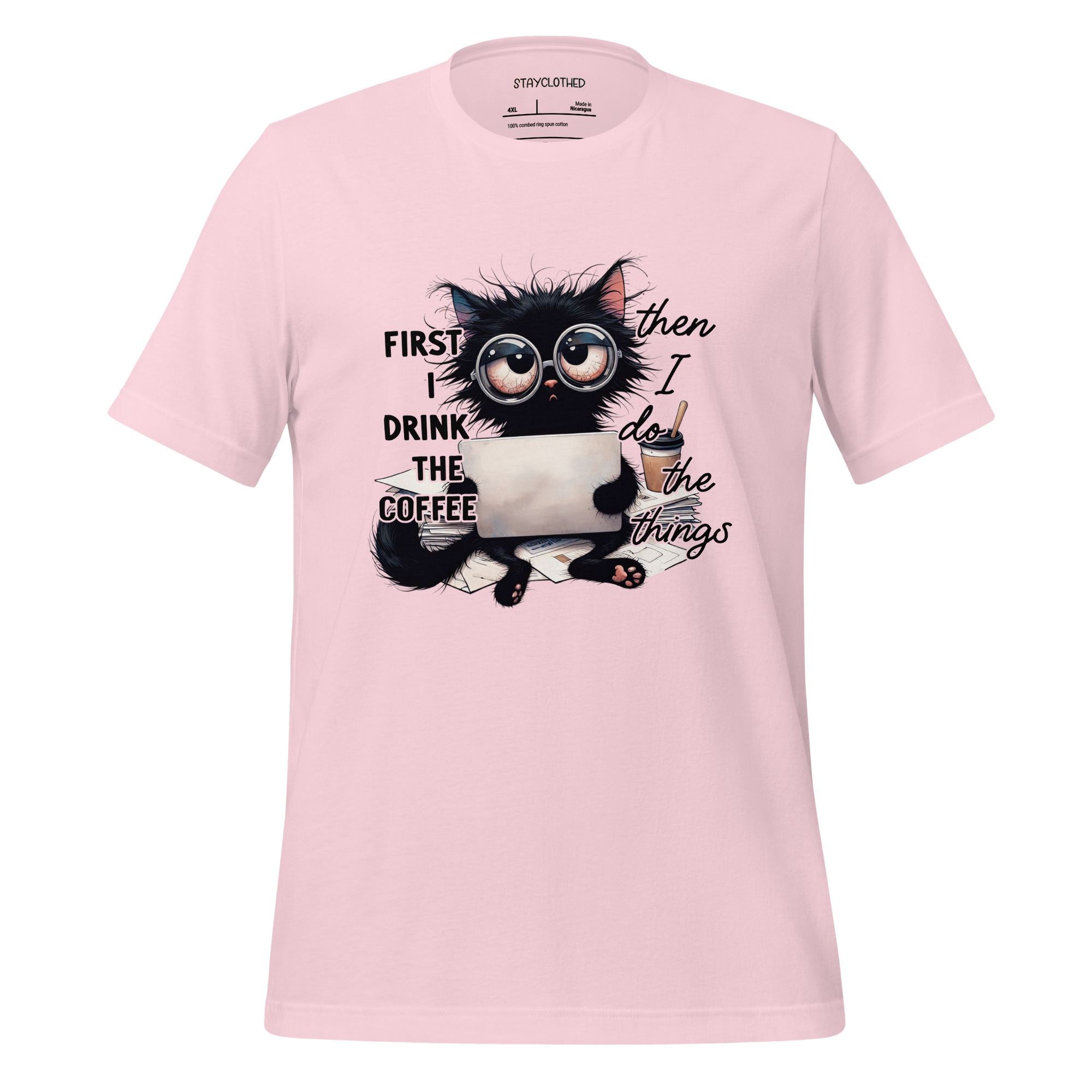 Pink t-shirt with a cat graphic and text on a wooden surface, featuring the brand 'StayClothed'.