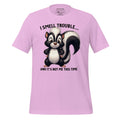 Pink t-shirt with a cartoon skunk design and text on a wooden surface, featuring the brand 'StayClothed'.