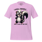 Pink t-shirt with a cartoon skunk design and text on a wooden surface, featuring the brand 'StayClothed'.