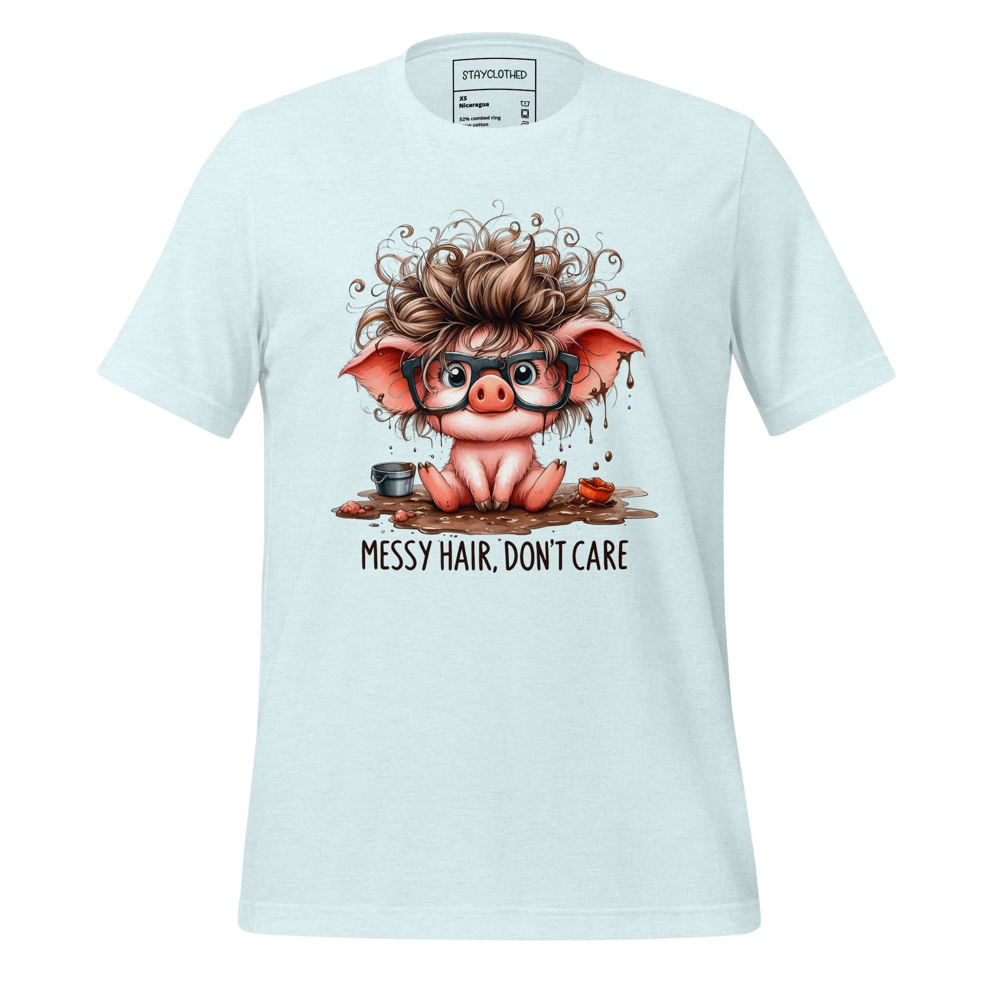 White t-shirt with a cartoon pig design and 'Messy Hair, Don't Care' text on a wooden surface.