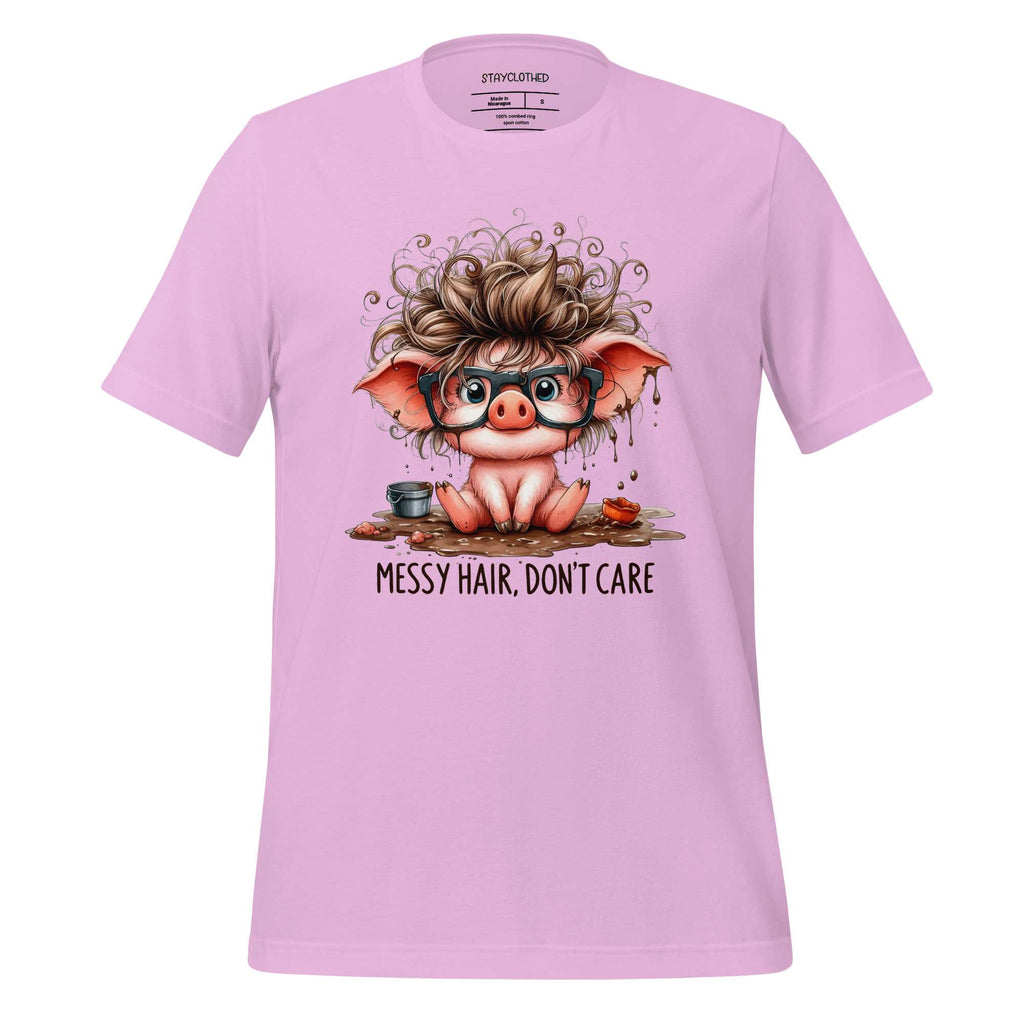 Pink t-shirt with a cartoon pig design and 'Messy Hair, Don't Care' text on a wooden surface.
