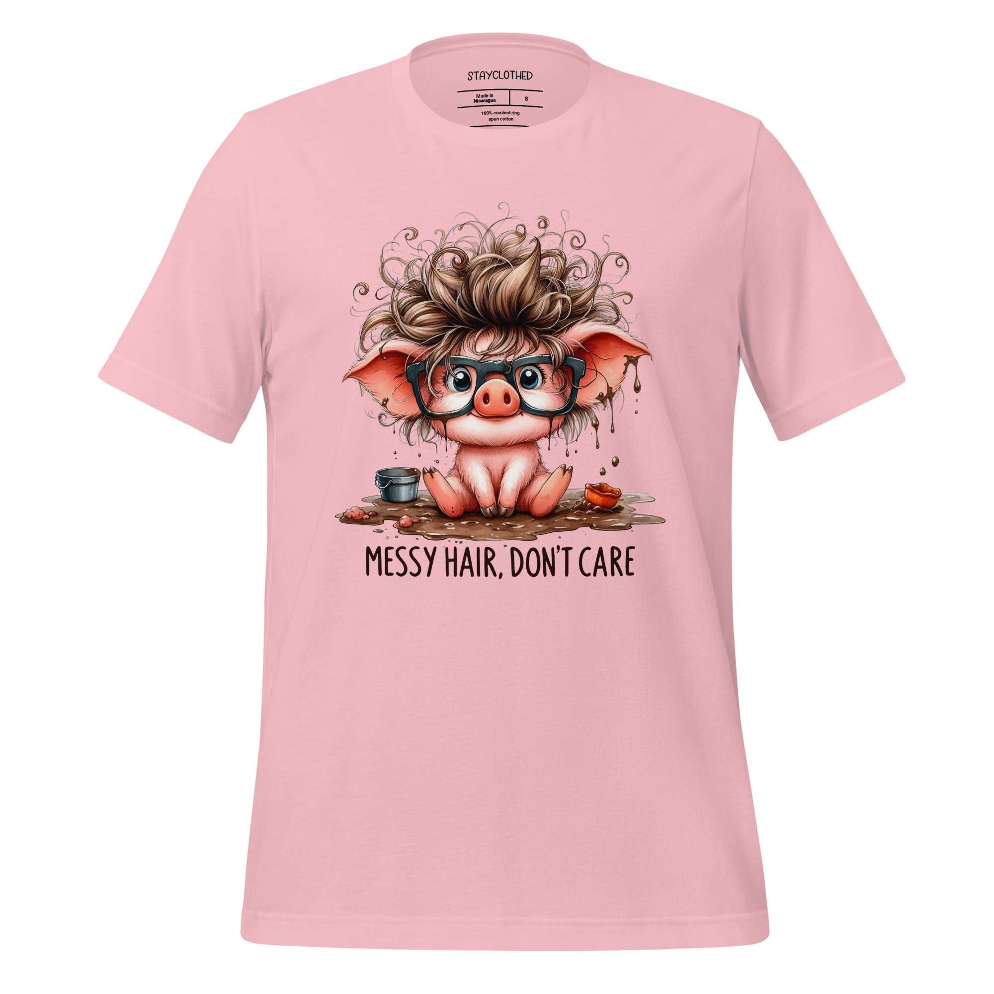 Pink t-shirt with a cartoon pig design and 'StayClothed' branding on a wooden surface.