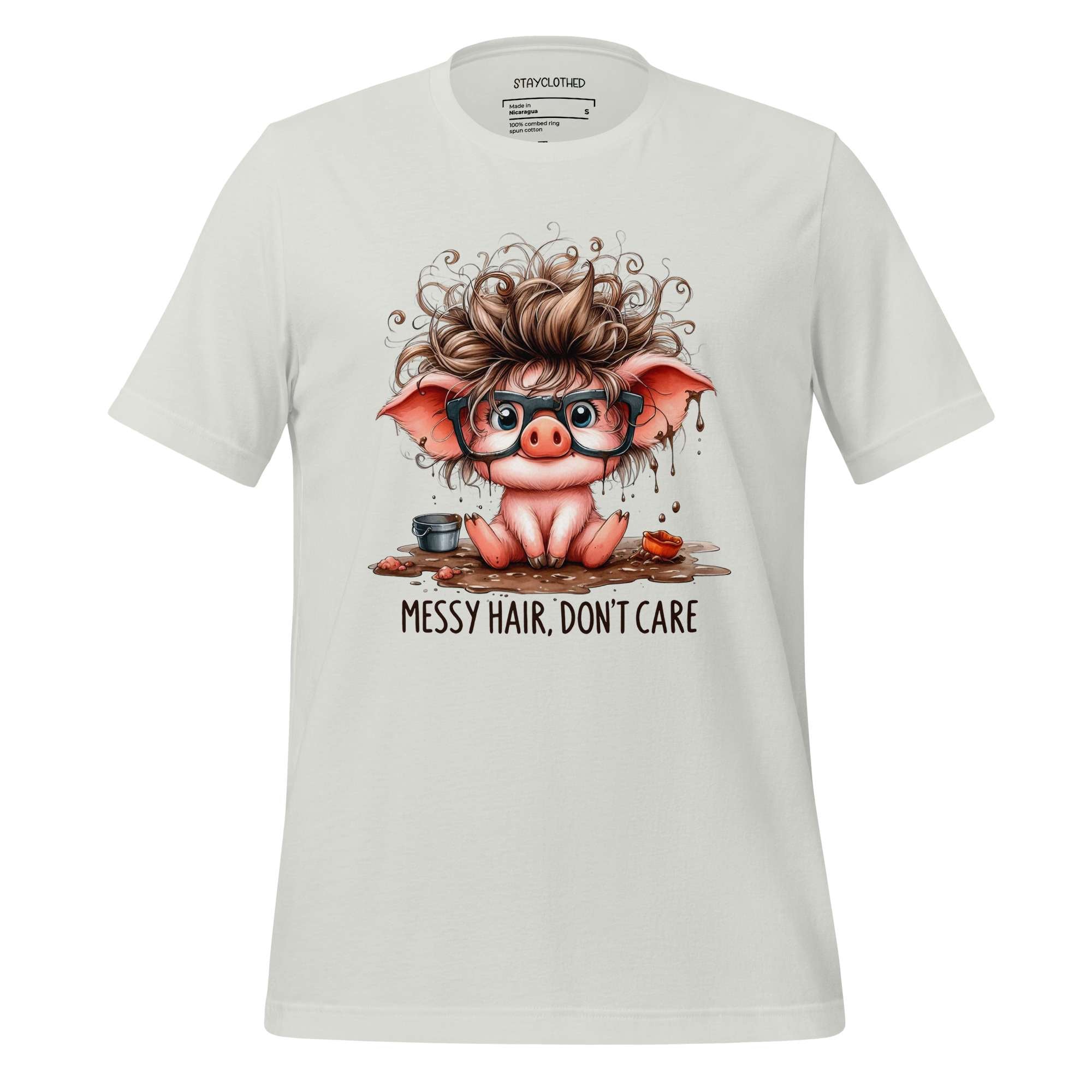 White t-shirt with a cartoon pig design and 'Messy Hair, Don't Care' text on a wooden surface.