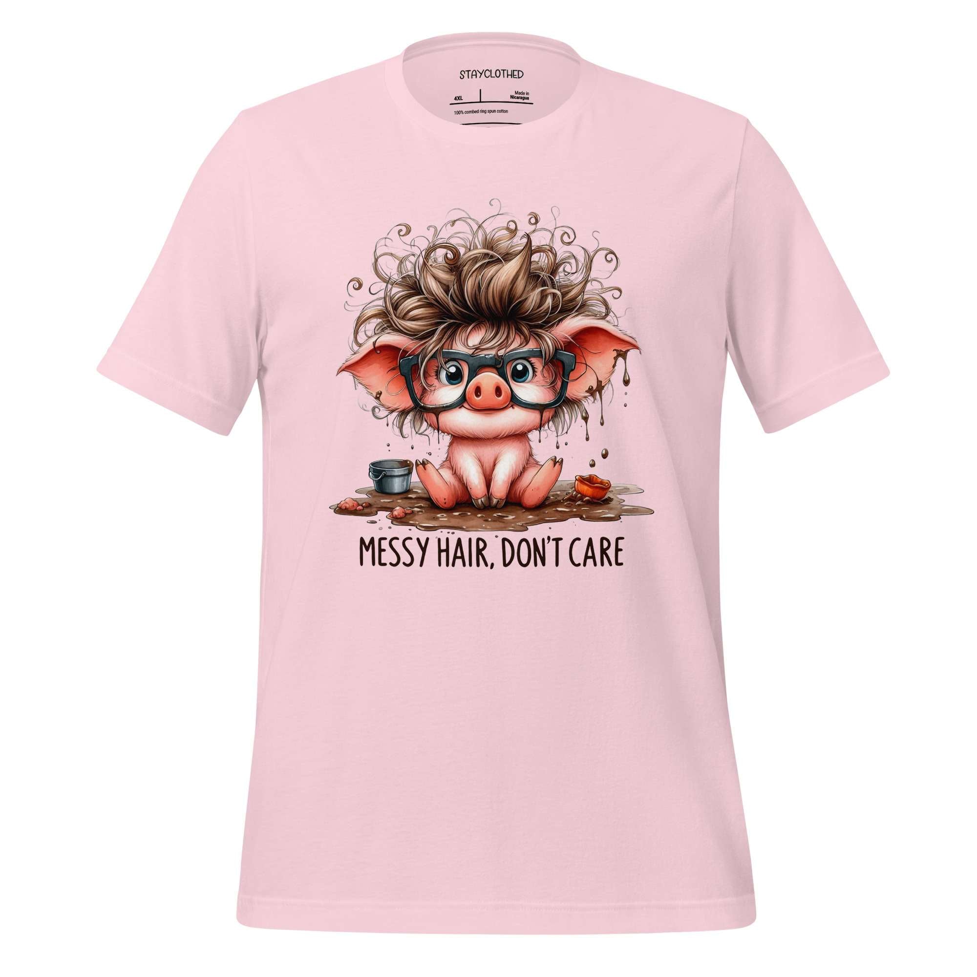 Pink t-shirt with a cartoon pig design and 'Messy Hair, Don't Care' text on a wooden surface.