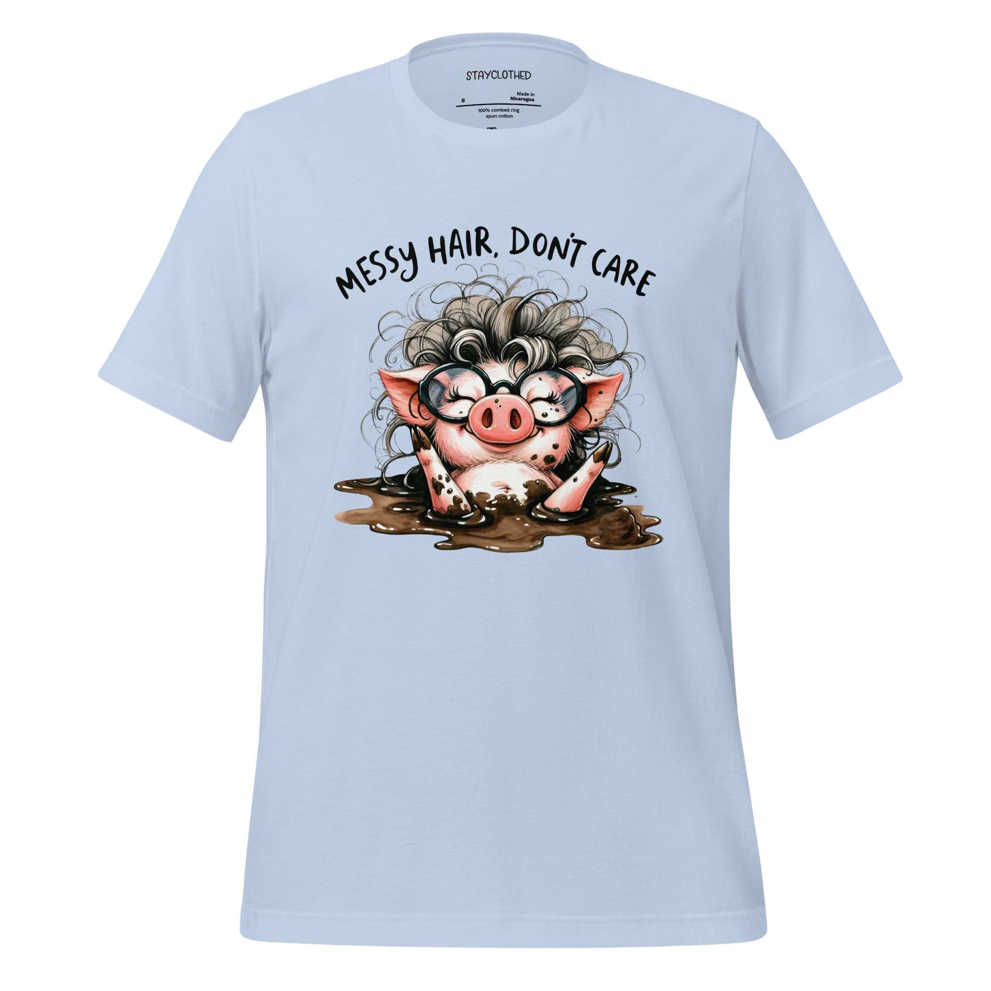 White t-shirt with a cartoon pig design and text 'Messy hair, don't care' on a wooden surface.