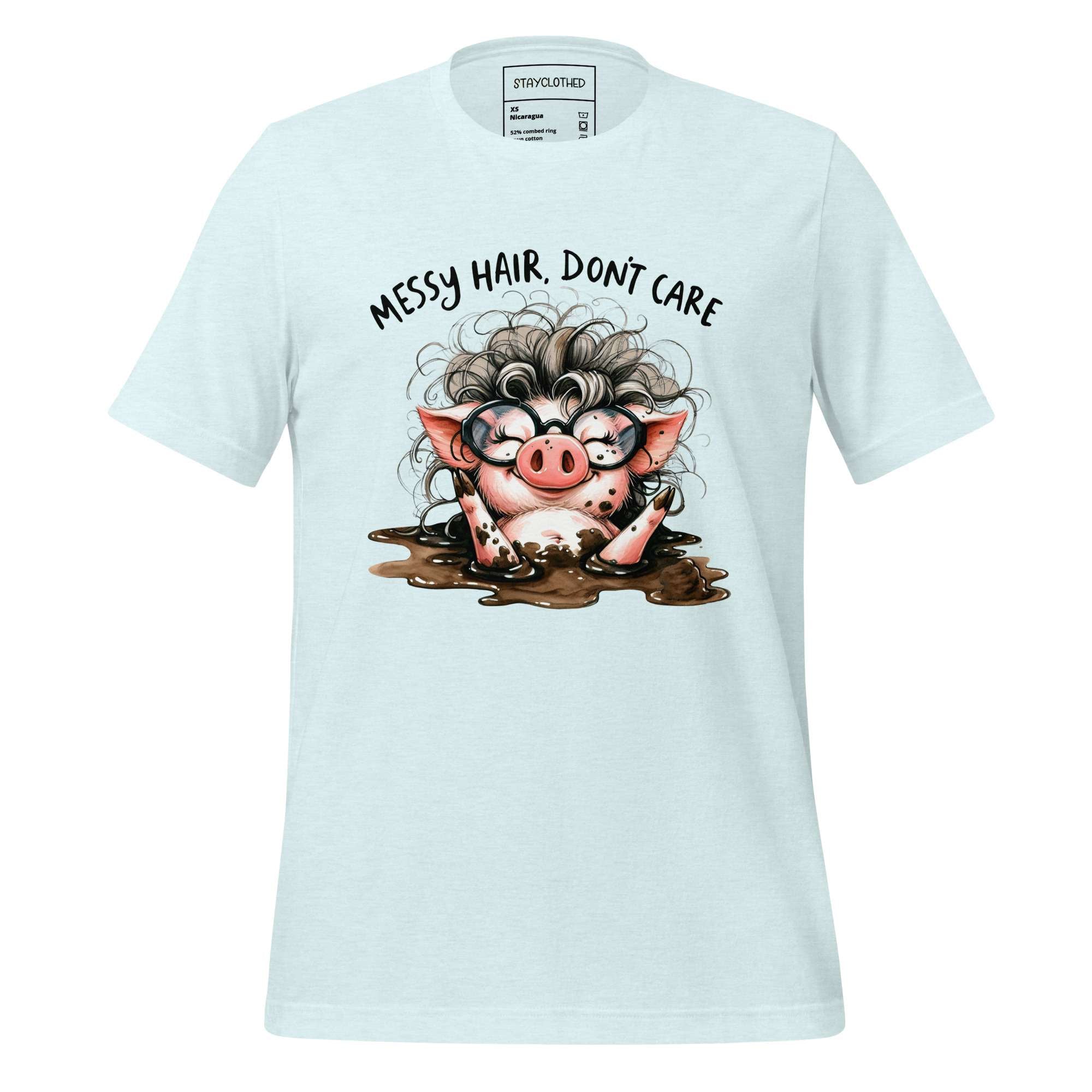 White t-shirt with a cartoon pig design and text 'Messy Hair, Don't Care' on a wooden surface.