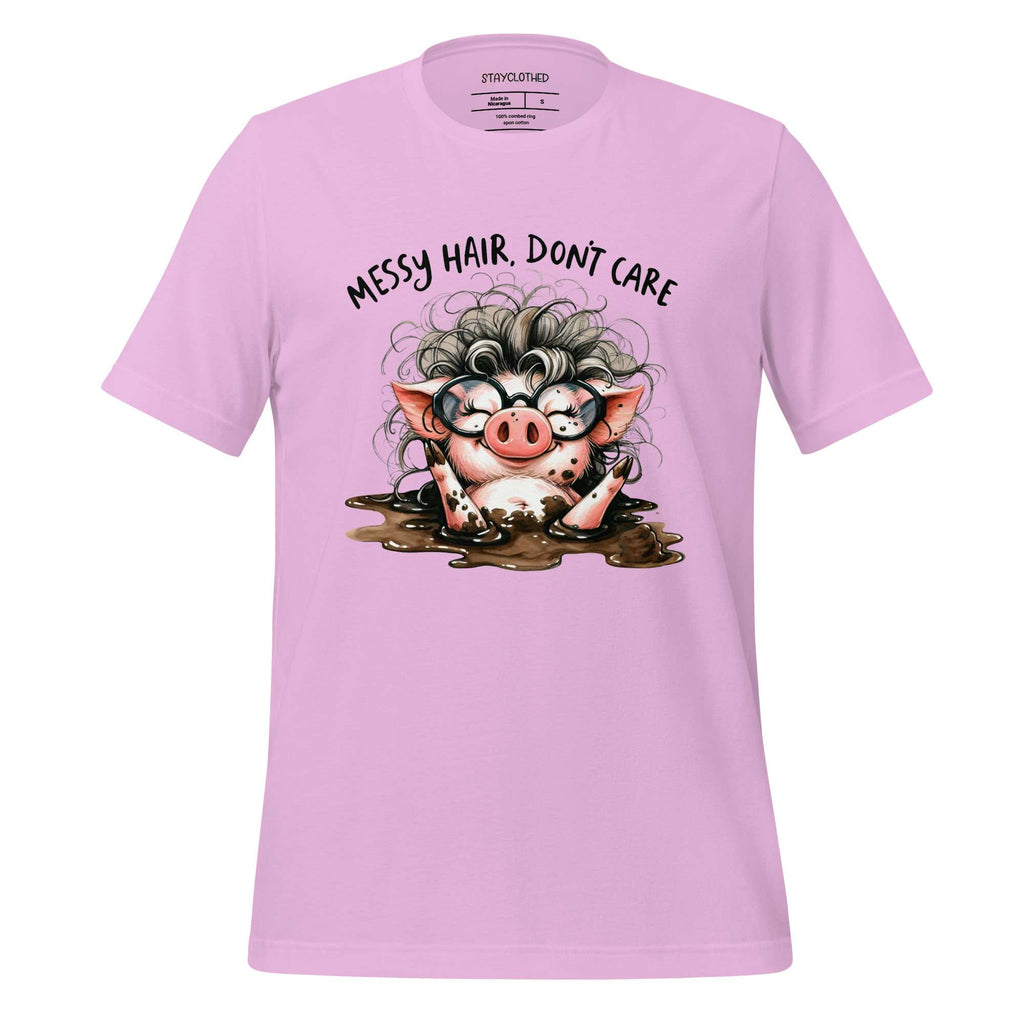 Pink t-shirt with a cartoon pig design and text 'Messy hair, don't care' on a wooden surface.