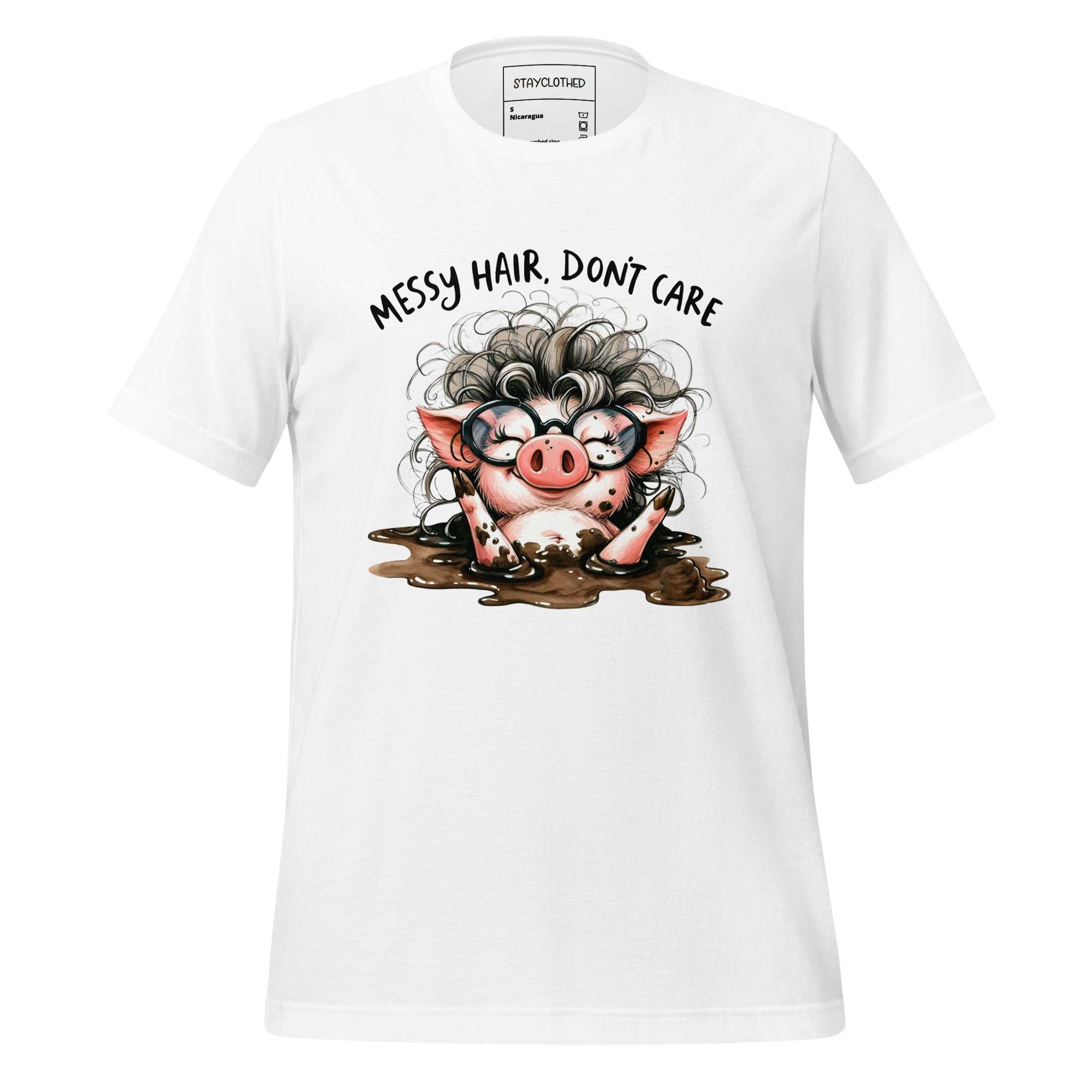 White t-shirt with a cartoon pig design and text 'Messy Hair, Don't Care' on a wooden surface.