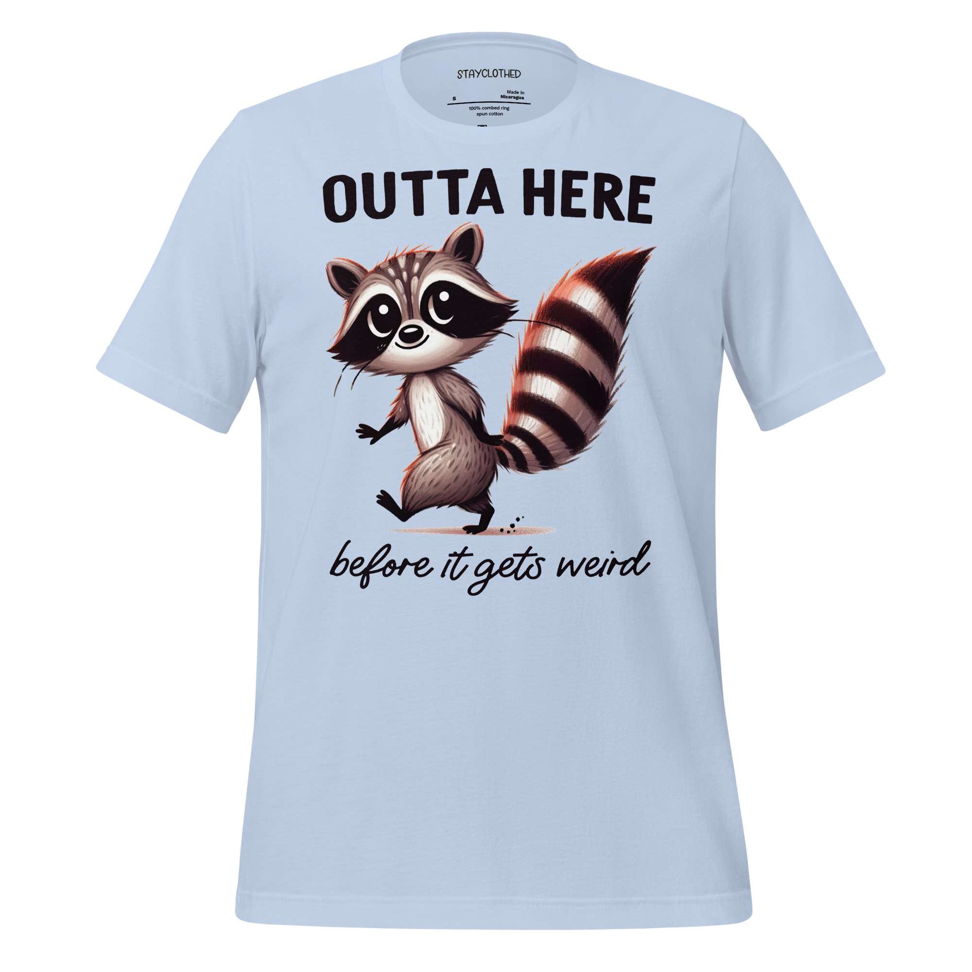 White t-shirt with a raccoon graphic and text on a wooden surface, featuring the brand 'StayClothed'.