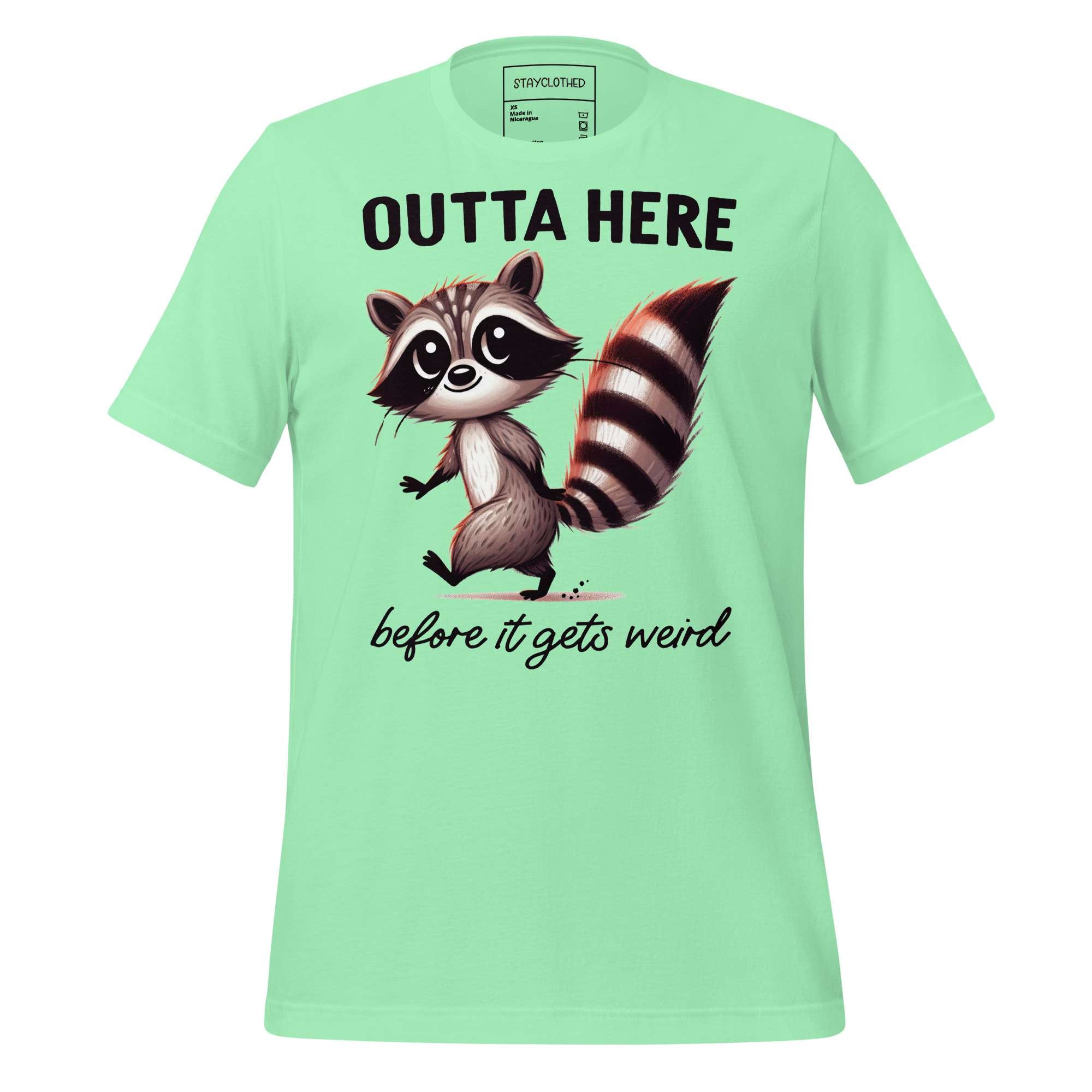 Light green t-shirt with a raccoon graphic and text on a wooden surface, featuring the brand 'StayClothed'.