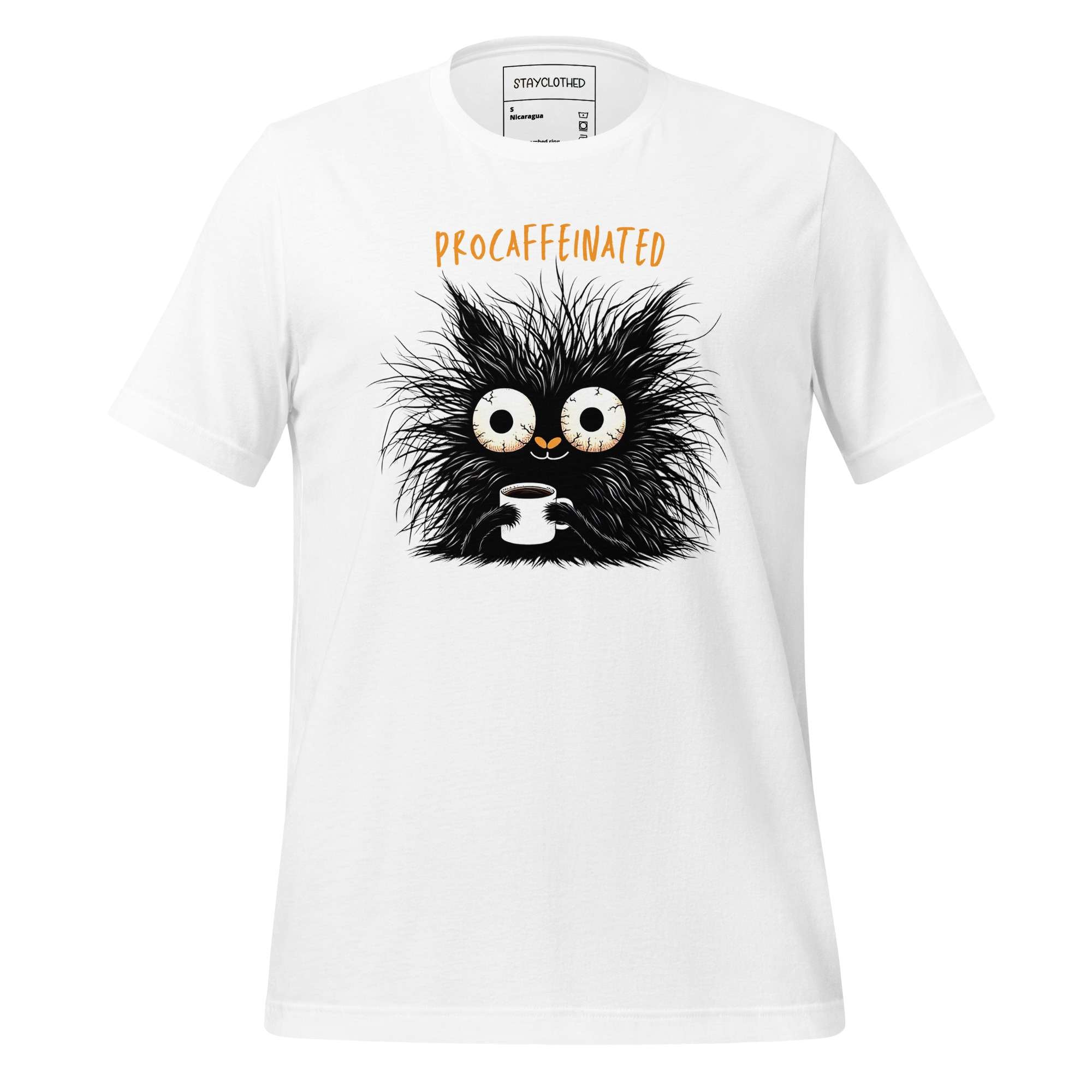 White t-shirt with a black creature holding a coffee cup graphic on a wooden surface, featuring the brand 'StayClothed'.