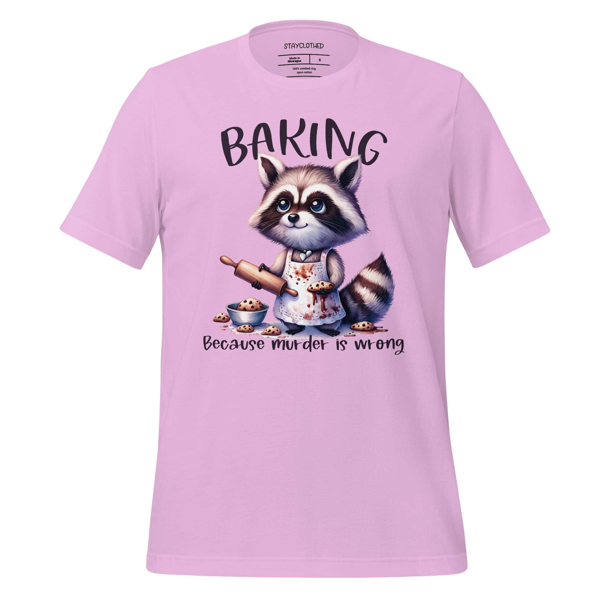 Pink t-shirt with a raccoon graphic and text on a wooden surface, featuring the brand 'StayClothed'.