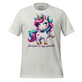 White t-shirt with a colorful unicorn graphic and text on a wooden surface, featuring the brand 'StayClothed'.