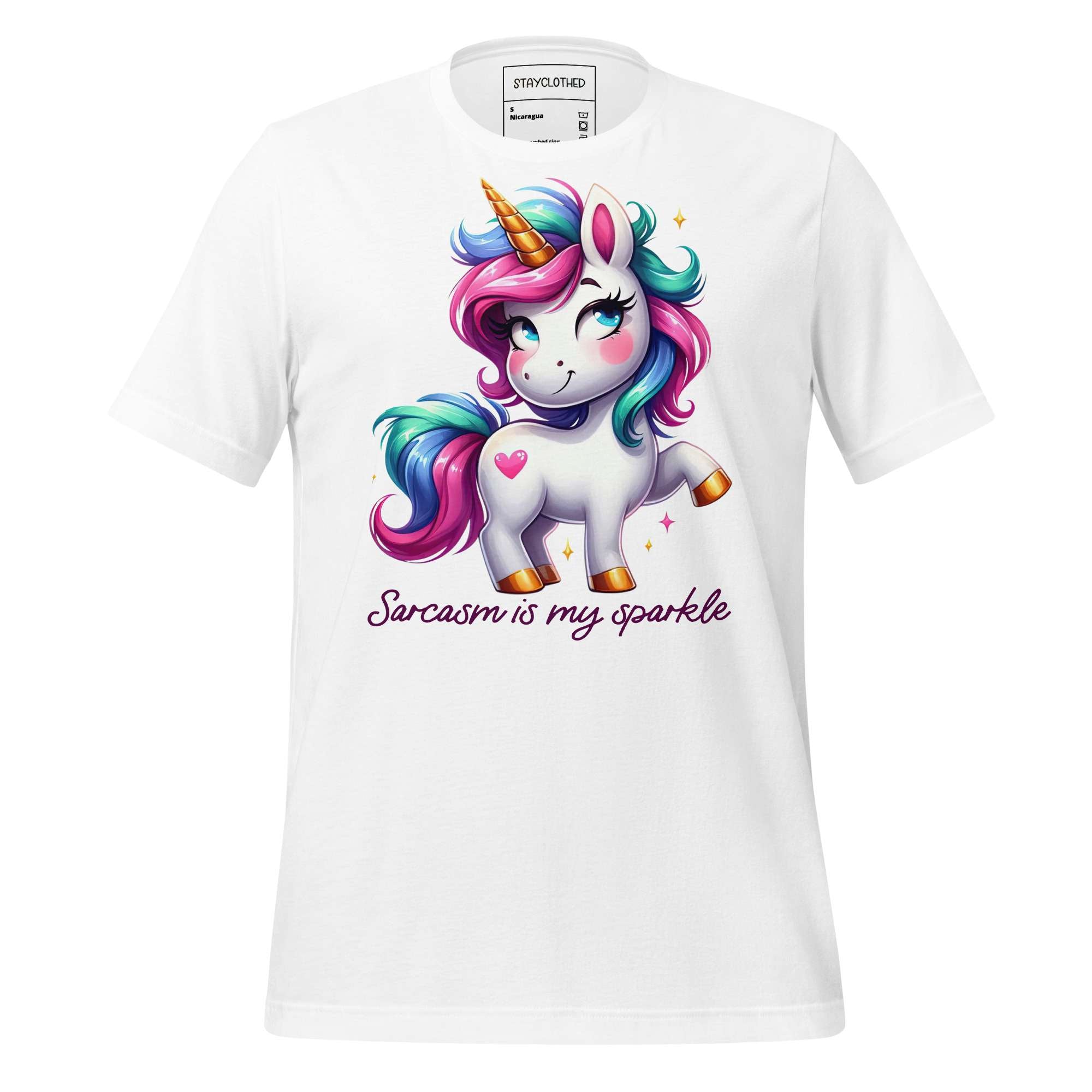 White t-shirt with a colorful unicorn graphic and text on a wooden surface, featuring the brand 'StayClothed'.