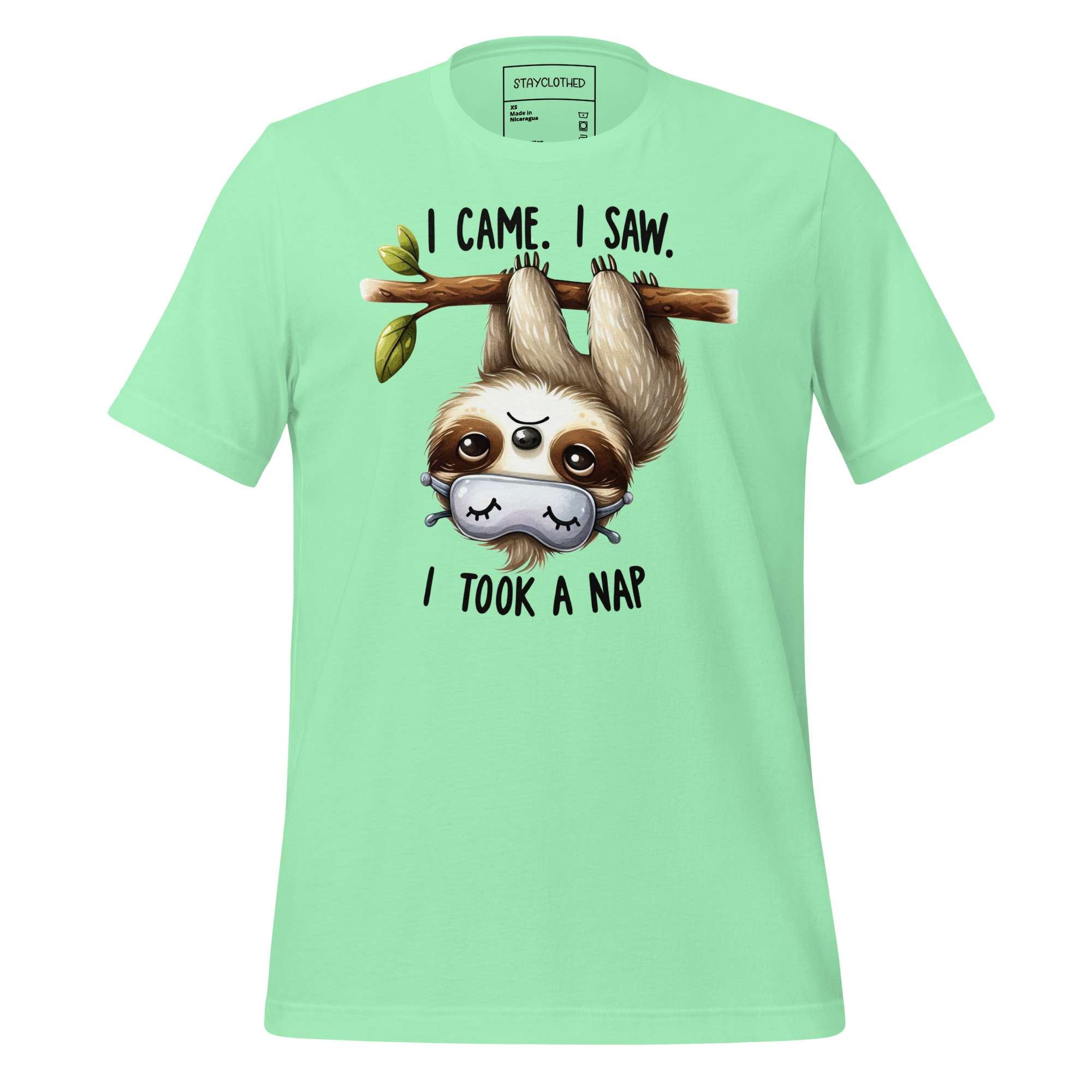 Light green t-shirt with a sloth graphic and text on a wooden surface, featuring the brand 'StayClothed'.