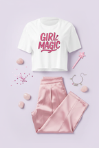 Girl Magic Pink Graphic Crop Top flat lay styled with a pink skirt and soft pink accessories