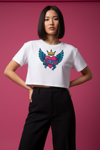 Model wearing the GRL PWR Winged Heart Crop Top in a pink studio scene with black trousers