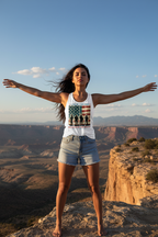 Model wearing the Land of the Free Because of the Brave Racerback Tank Top in a mountain landscape scene