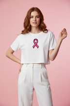 Model wearing the Pink Ribbon Awareness Crop Top in a soft pink studio scene