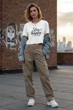 Model wearing the Stay Happy Cropped Festival Top in front of a graffiti wall
