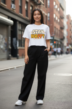 Model wearing the Stay Happy Women’s Crop Top in an urban streetwear scene