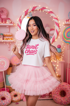 Model wearing the Sweet Chaos Pink Script Crop Top in a pink plush studio scene