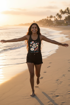 Model wearing the Tastes Like Freedom Racerback Tank Top while walking on the beach at sunset