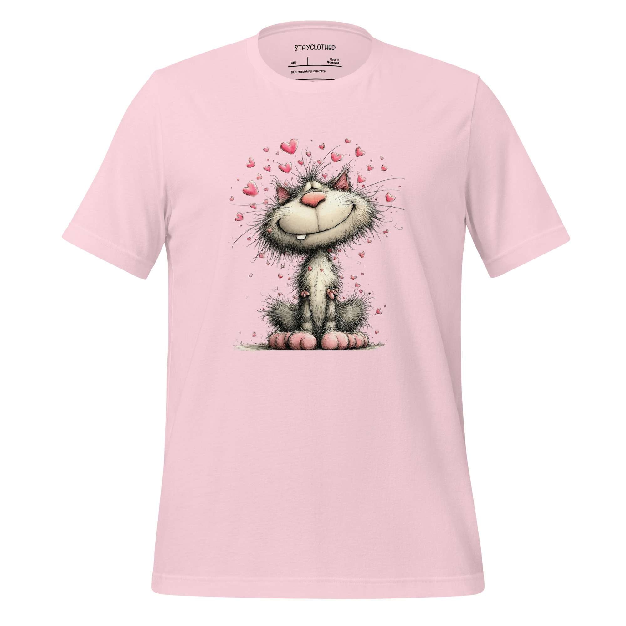 Pink t-shirt with a cartoon cat design on a wooden surface, featuring the brand 'StayClothed'.