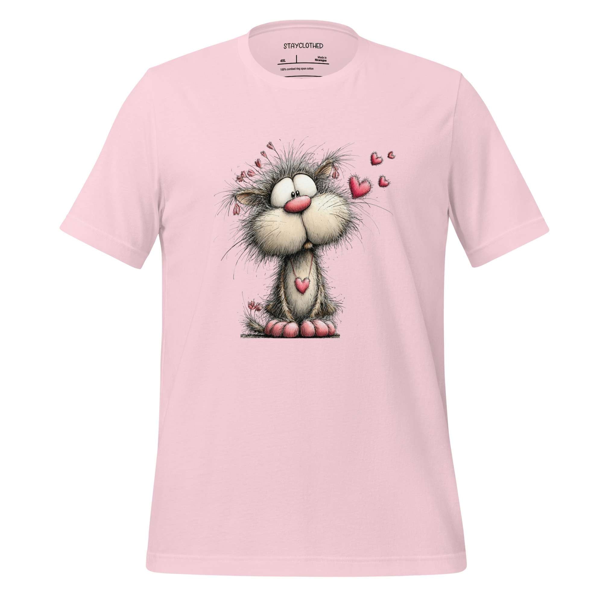 Pink t-shirt with a cartoon cat design on a wooden surface, featuring the brand 'StayClothed'.